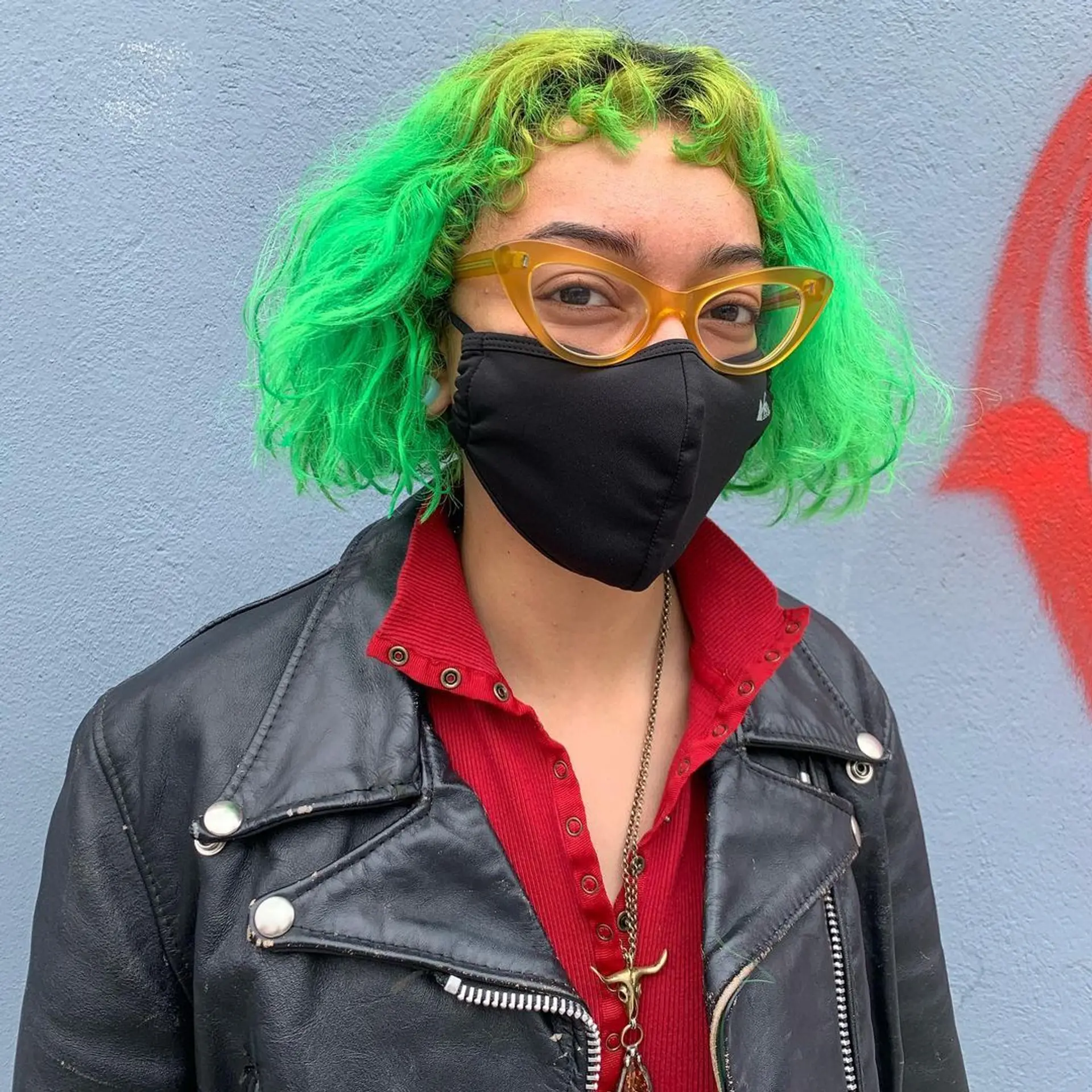 A curly, short bob in neon green, featuring a defined fringe for a bold and modern look. 1