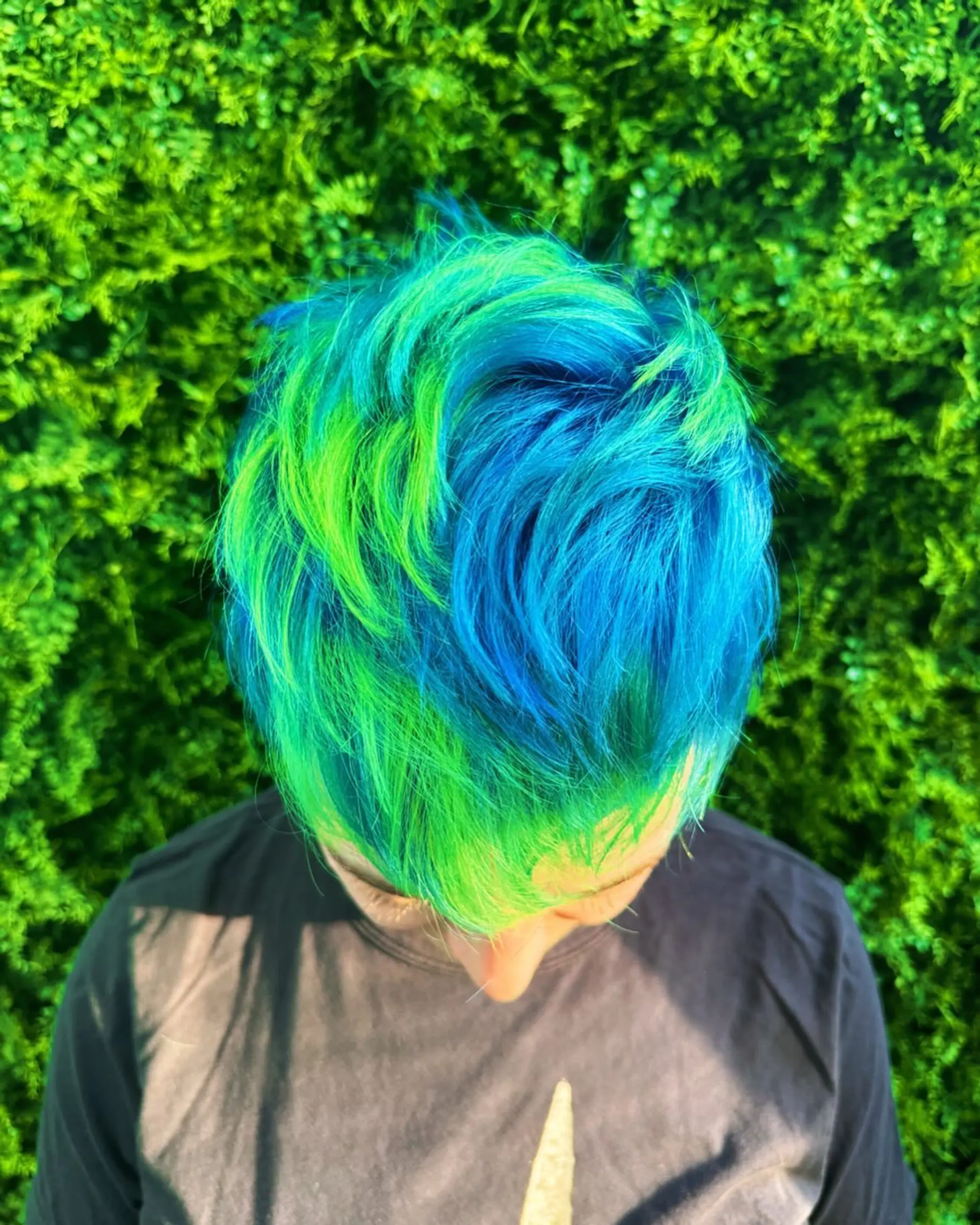 A short, straight pixie cut with a vibrant two-tone neon color. 1