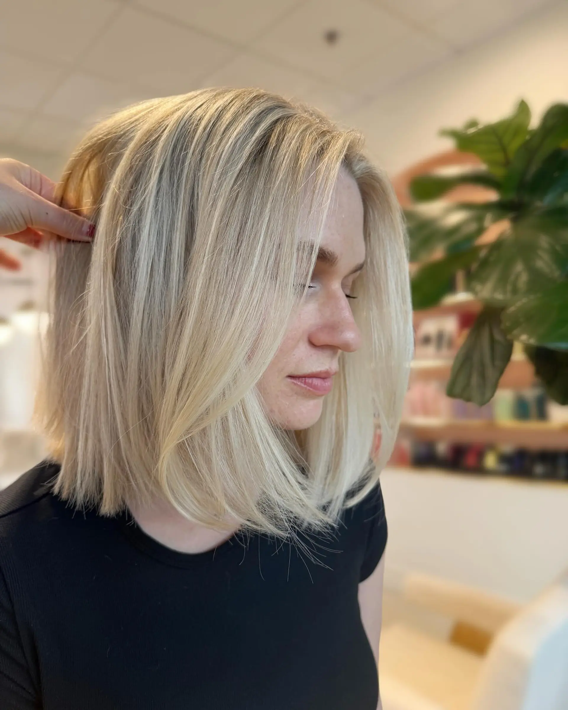 A sleek, blunt shoulder-skimming lob featuring bright dimensional blonde tones and soft face-framing layers. 1