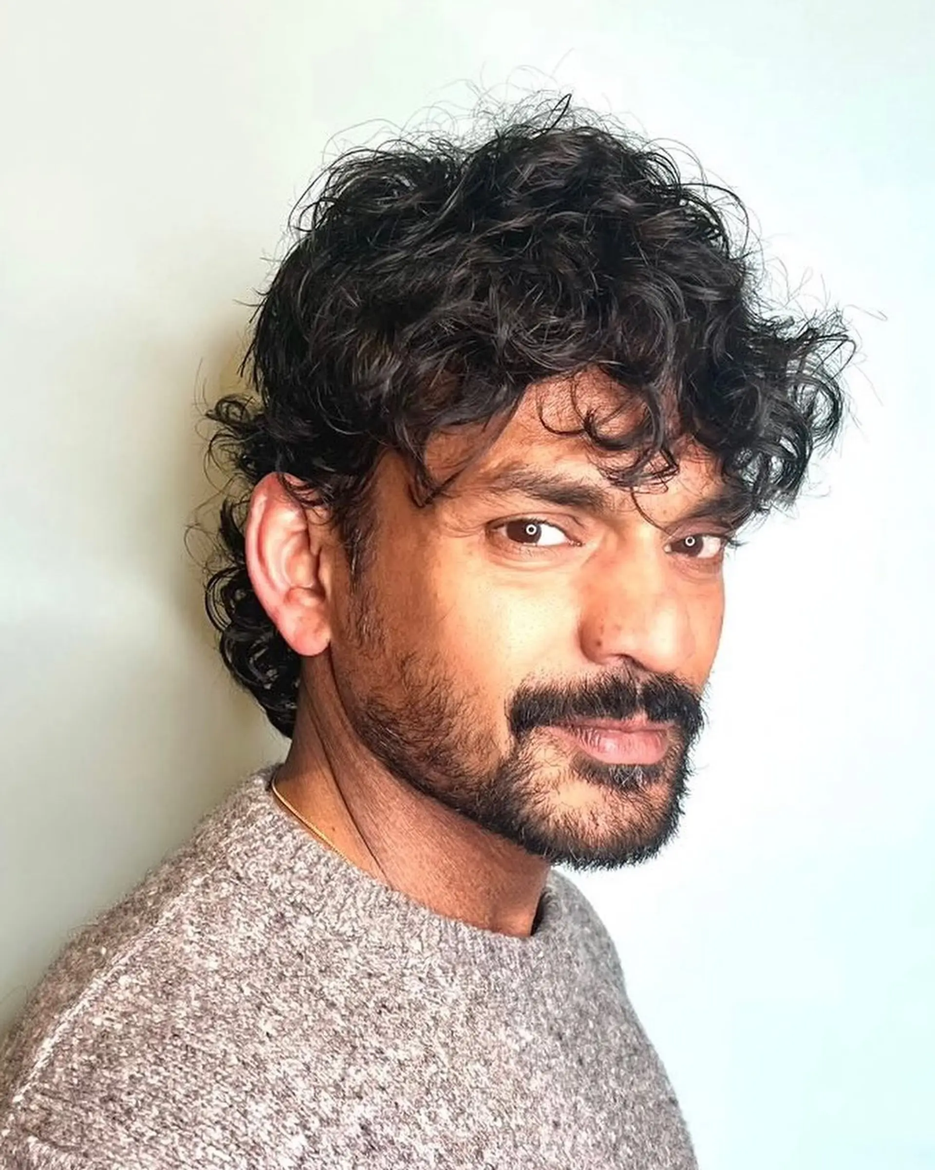 A textured curly crop with a natural fringe and slightly tapered sides. 1