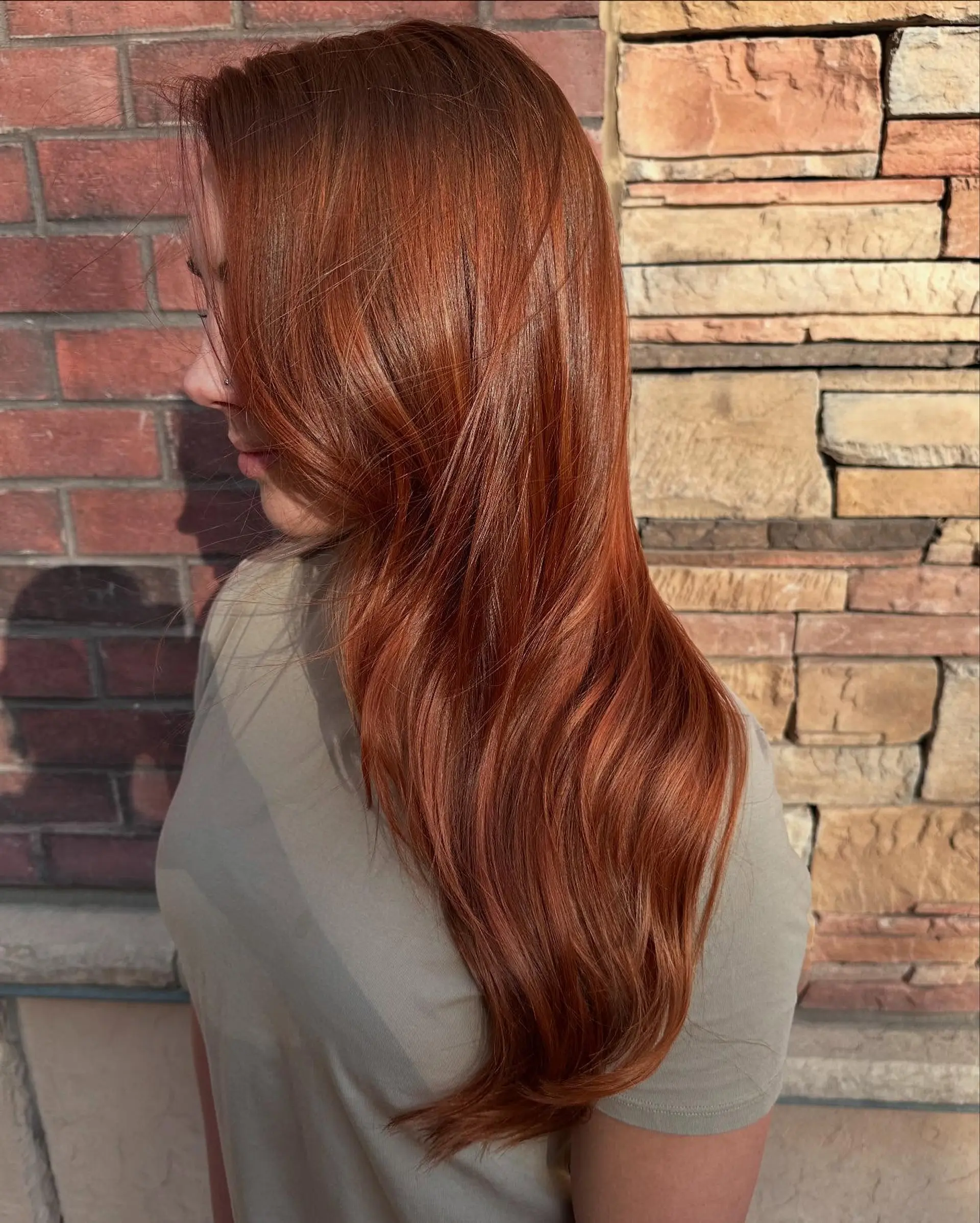 Rich all-over copper red color styled in sleek, long layers with a smooth blowout and subtle soft wave at the ends. 1