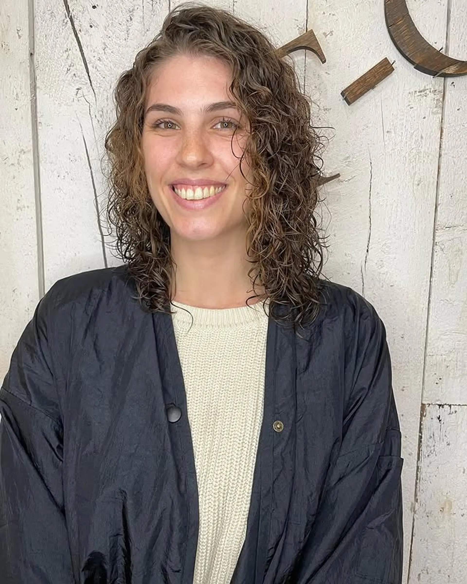 A curly shag with face-framing layers that is cut to a medium length. 1