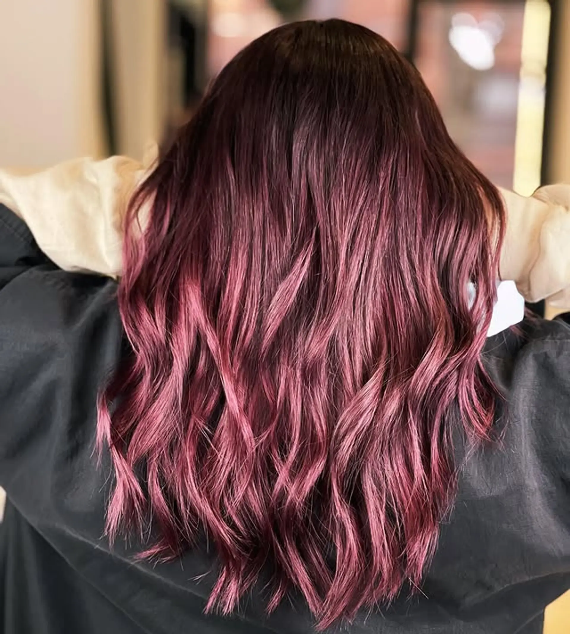A vibrant ombre that fades from burgundy to pink, styled with soft waves. 1