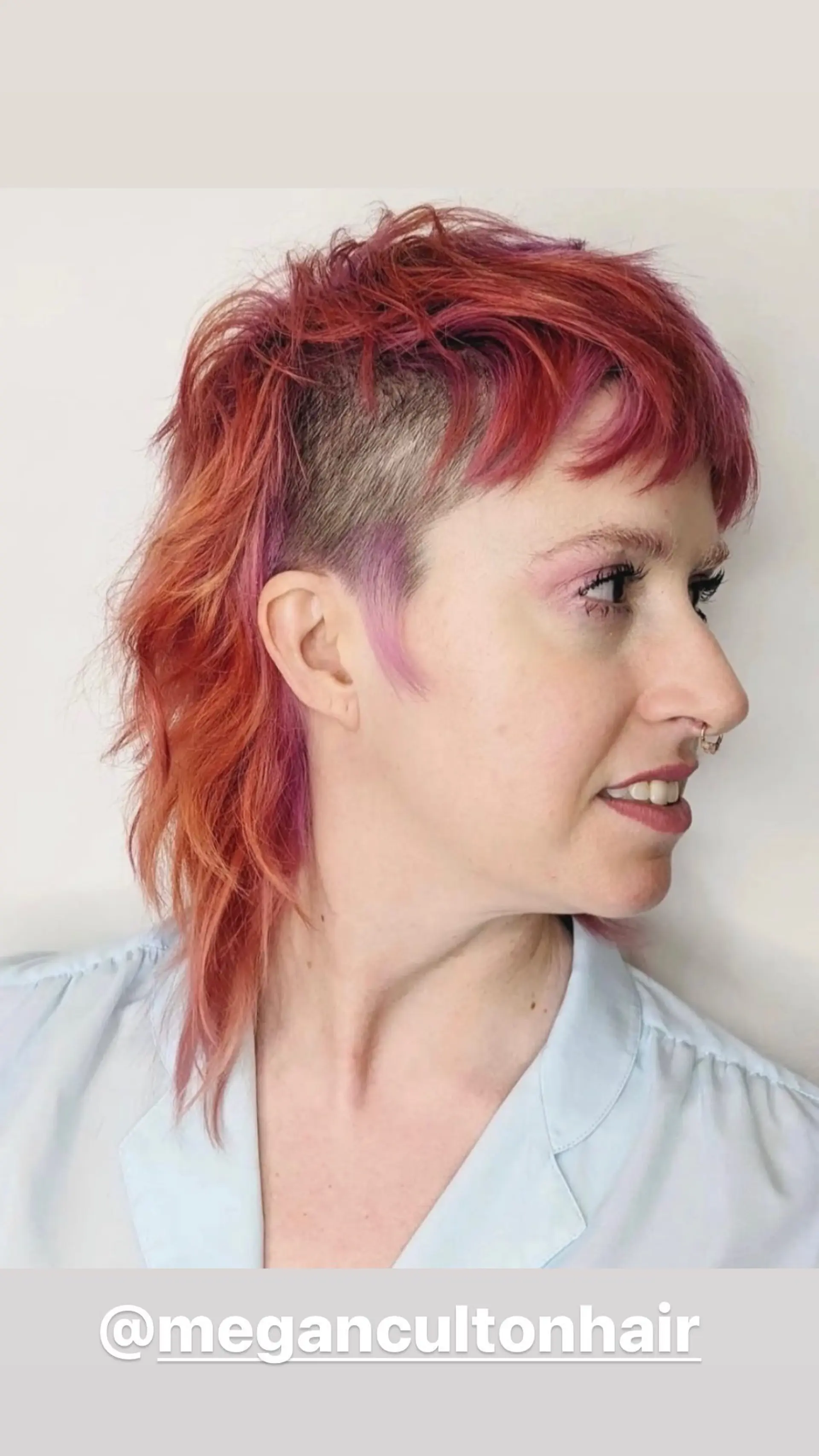 A modern mullet with shaved sides and vibrant pink highlights throughout the red hair. 1