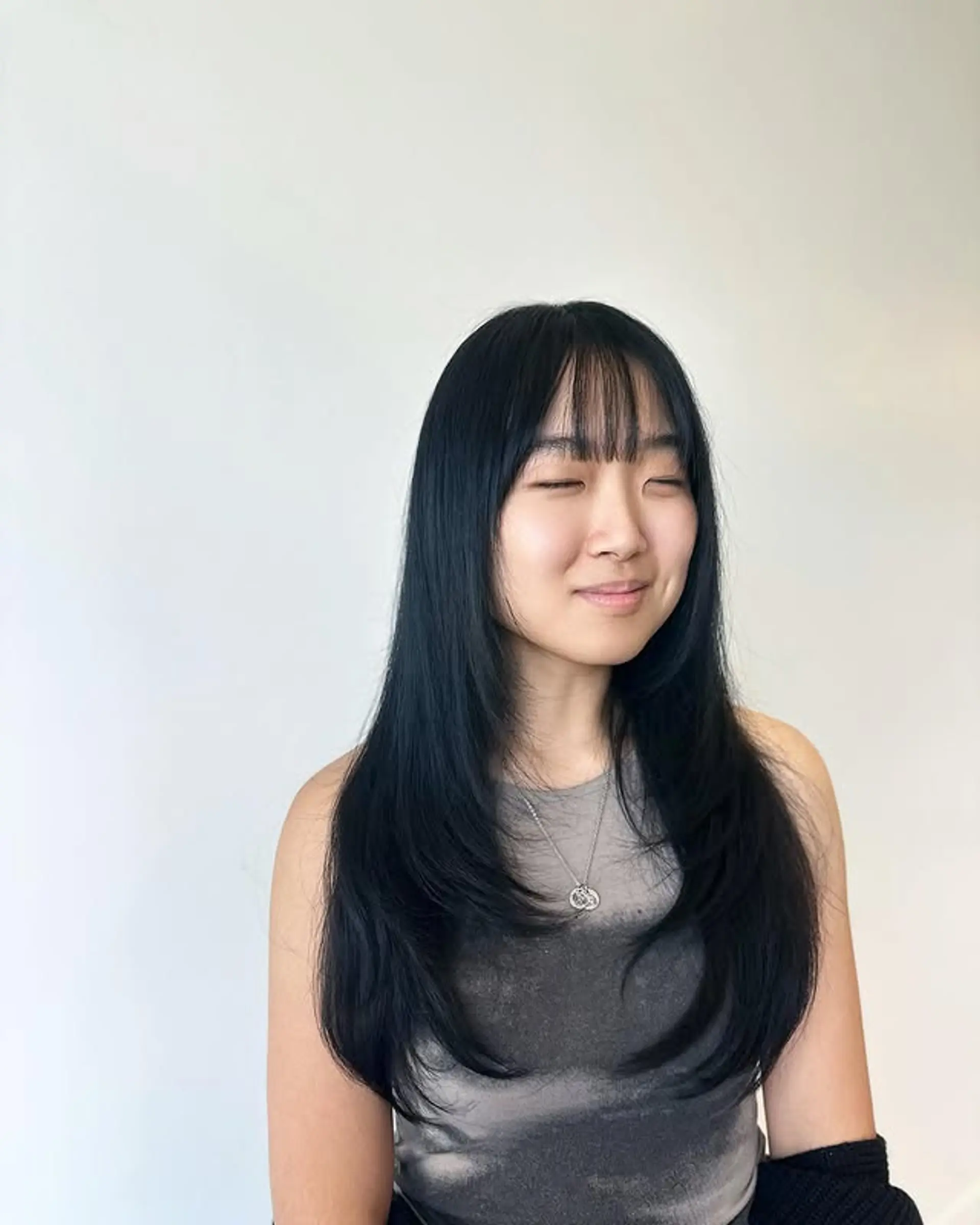 Long layered hairstyle with baby bangs. 1