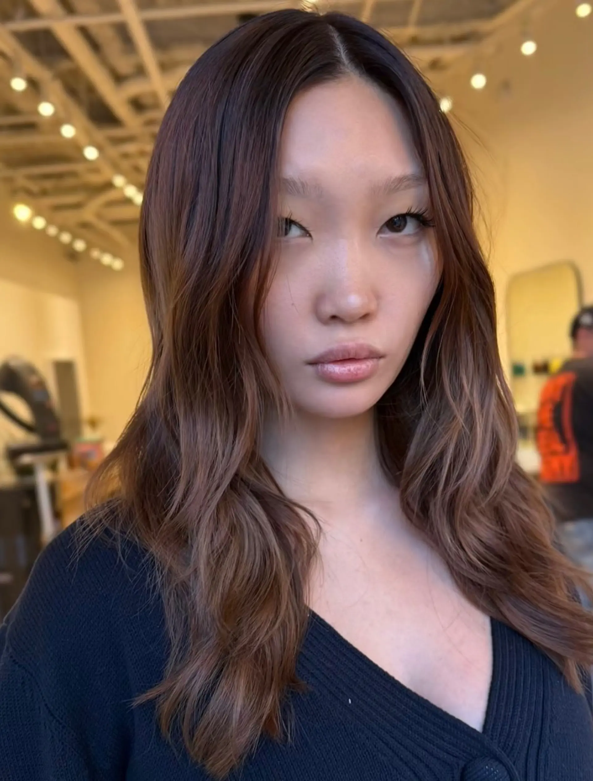 Long wavy brunette hair styled with a center part and soft face-framing layers. 1