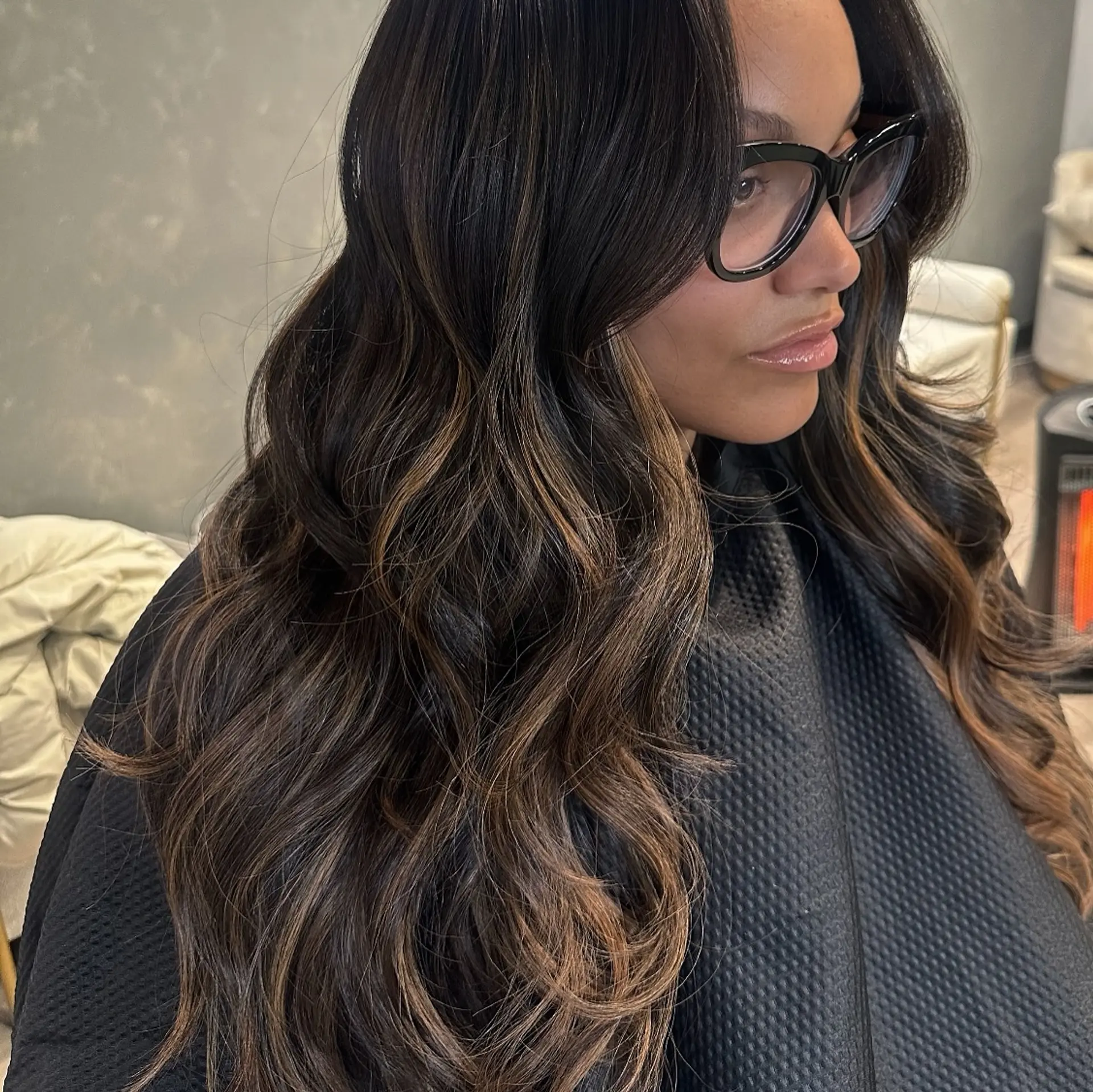 A long, layered hairstyle with waves and balayage highlights. 1