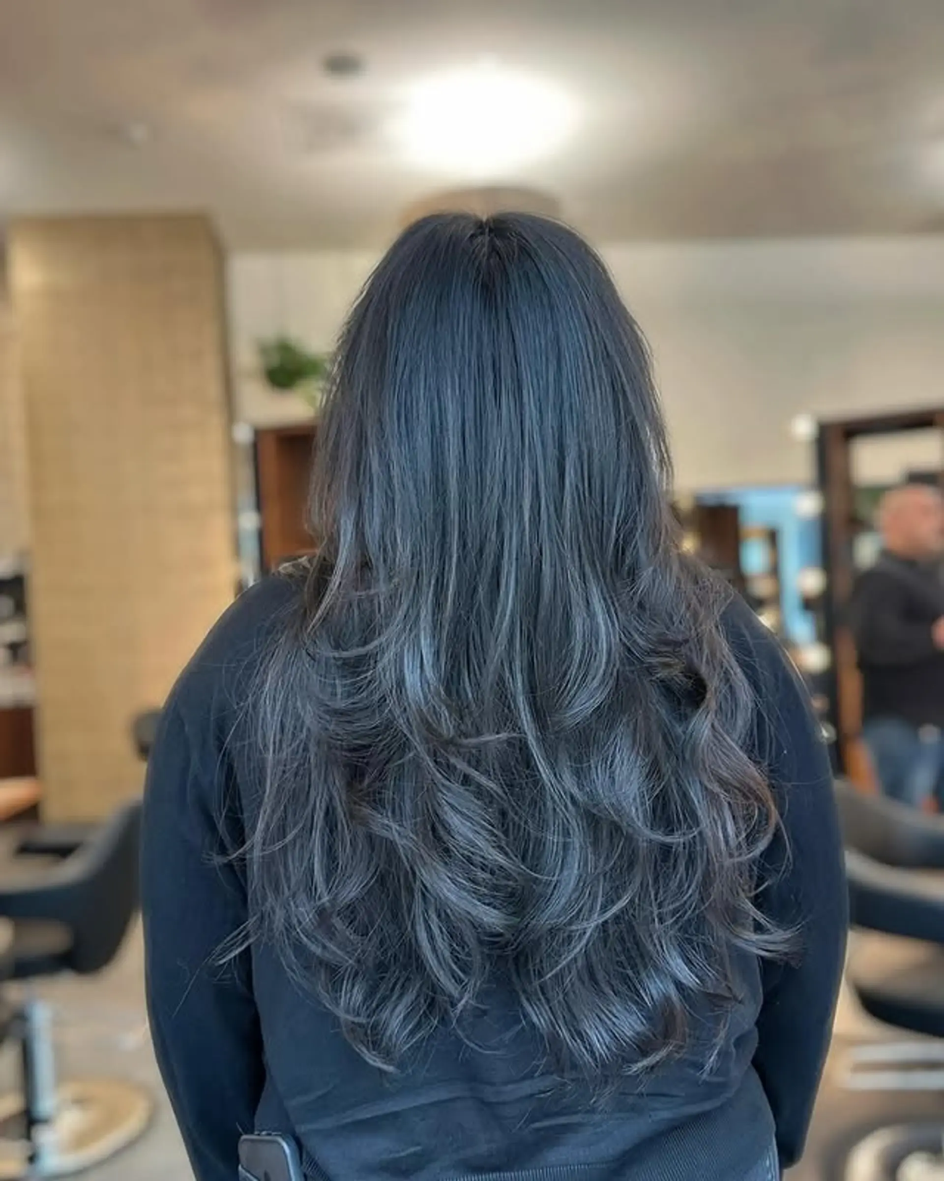 Long layered hairstyle with an ash blue balayage. 1