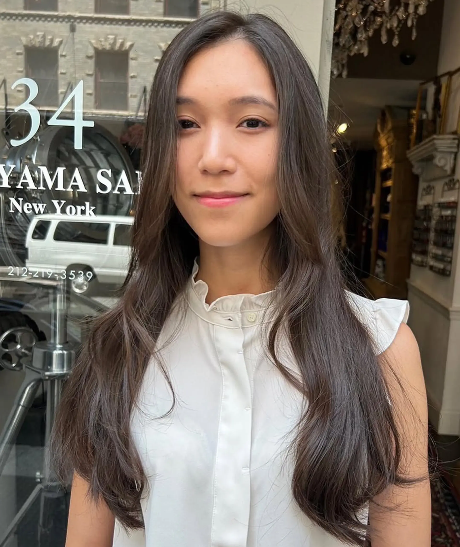 This hairstyle features long, dark brown hair with soft, flowing waves and a center parting, incorporating face-framing layers for a natural, elegant look. 2