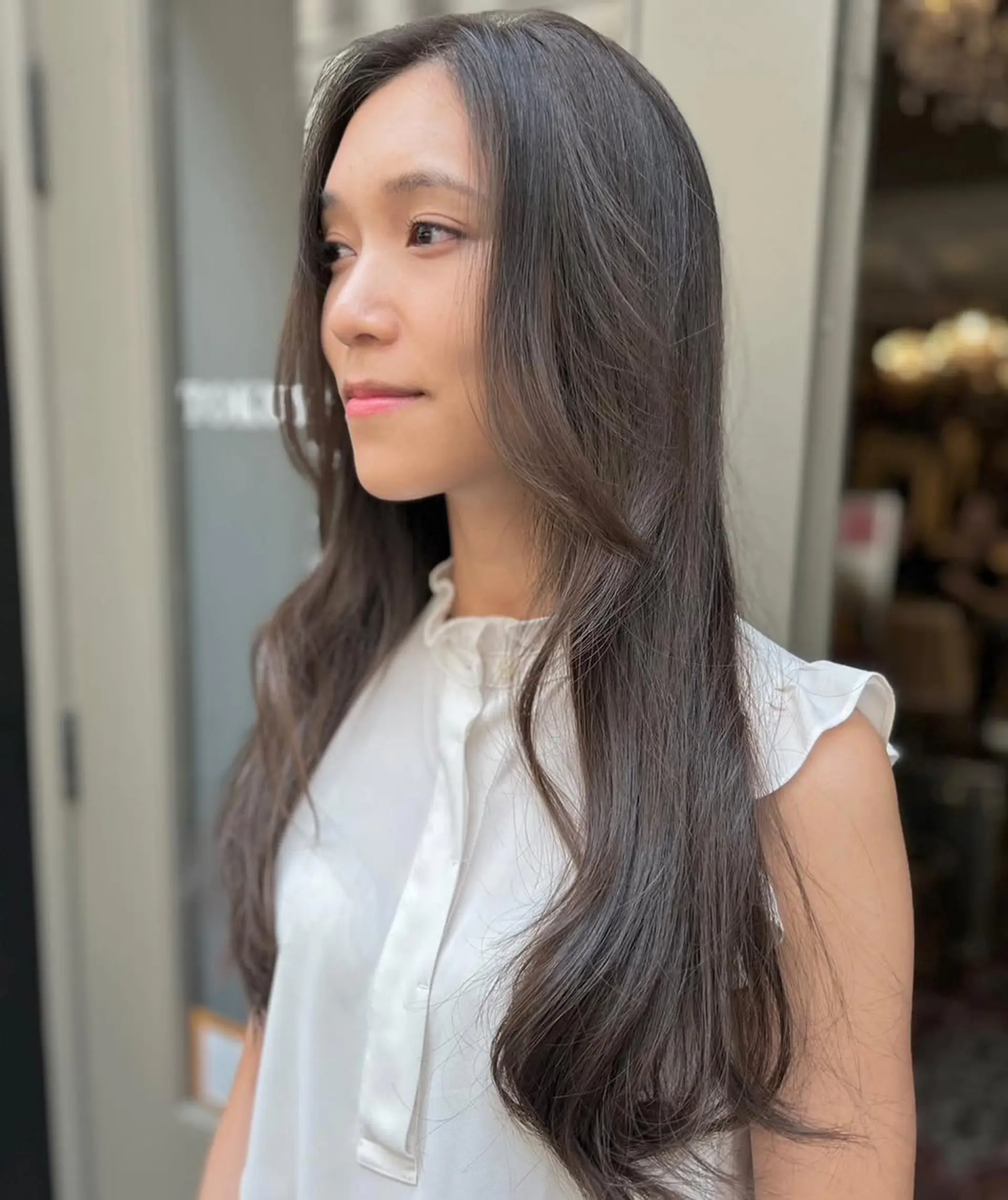 This hairstyle features long, dark brown hair with soft, flowing waves and a center parting, incorporating face-framing layers for a natural, elegant look. 3