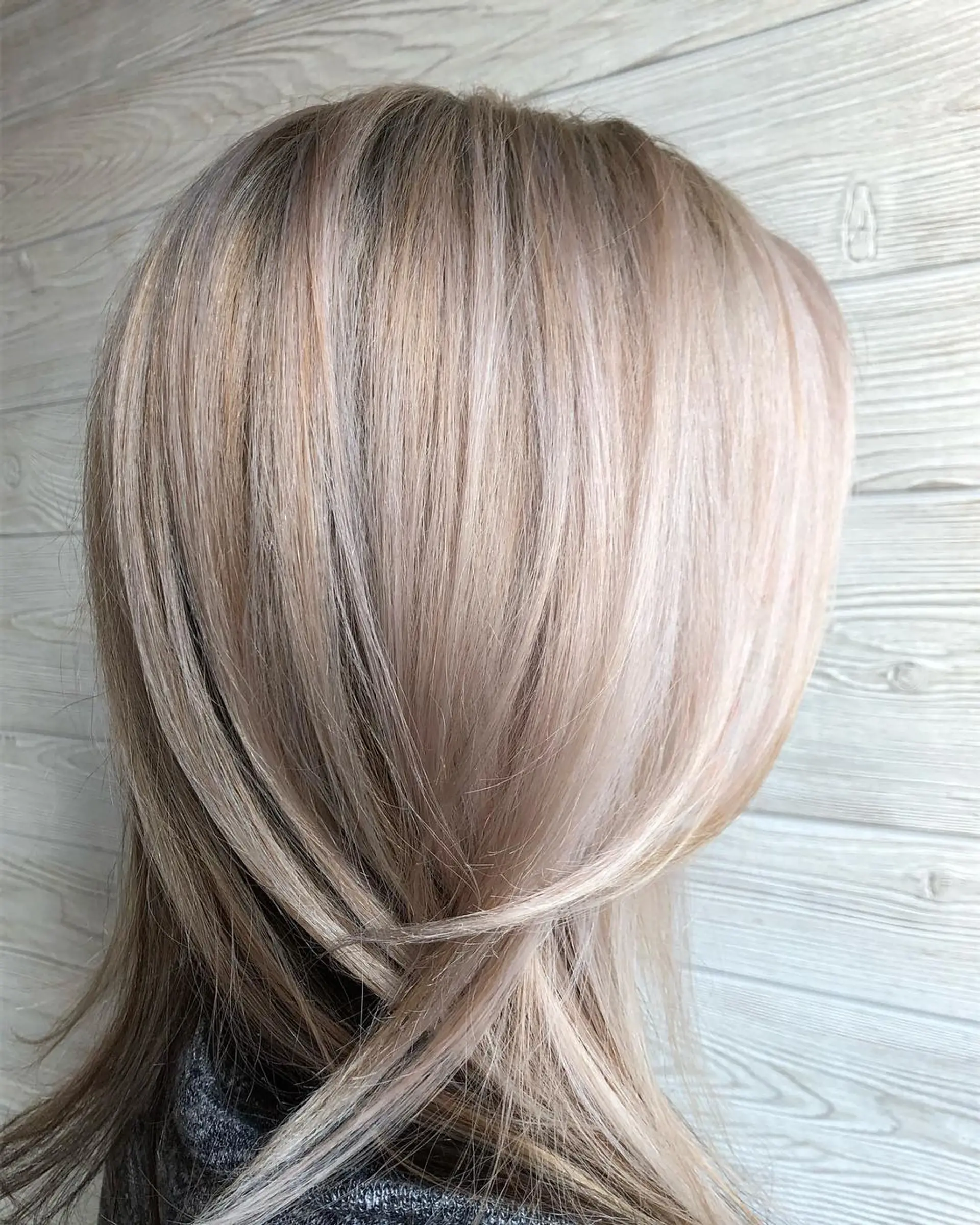 Medium-length straight hair styled in a smooth blowout featuring cool, icy ash blonde highlights. 1