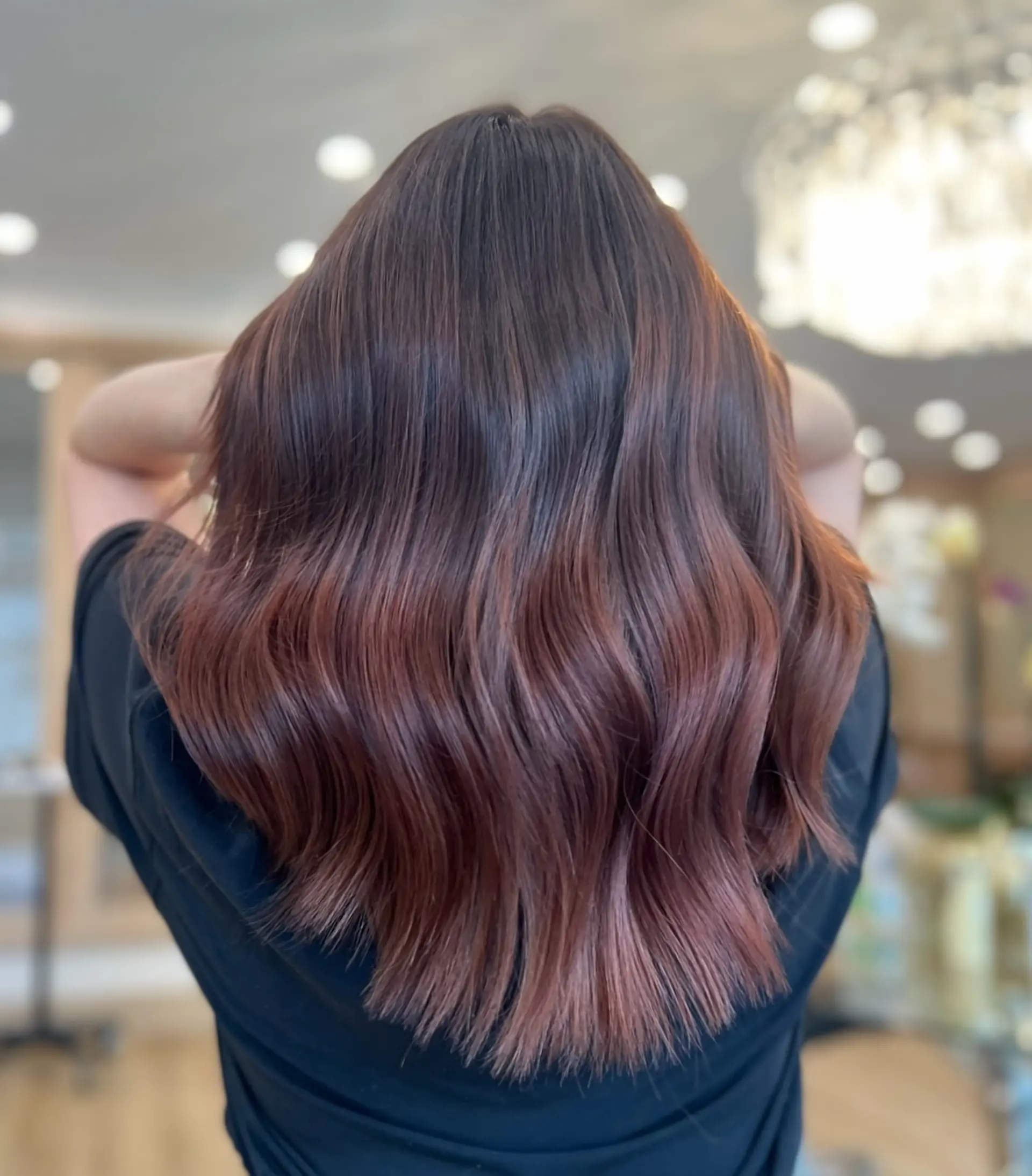Long, wavy hair with a dark base and copper balayage. 1