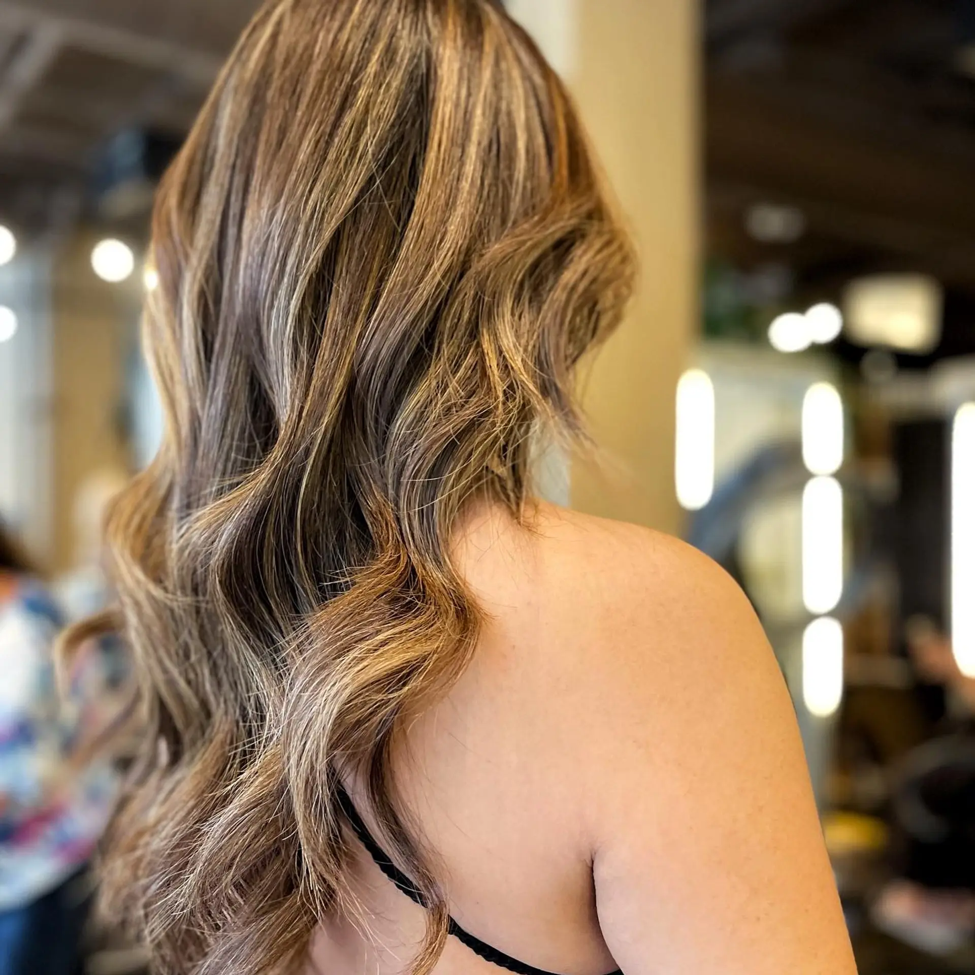 Long, wavy hair with a caramel balayage creating a dimensional and trendy look. 1