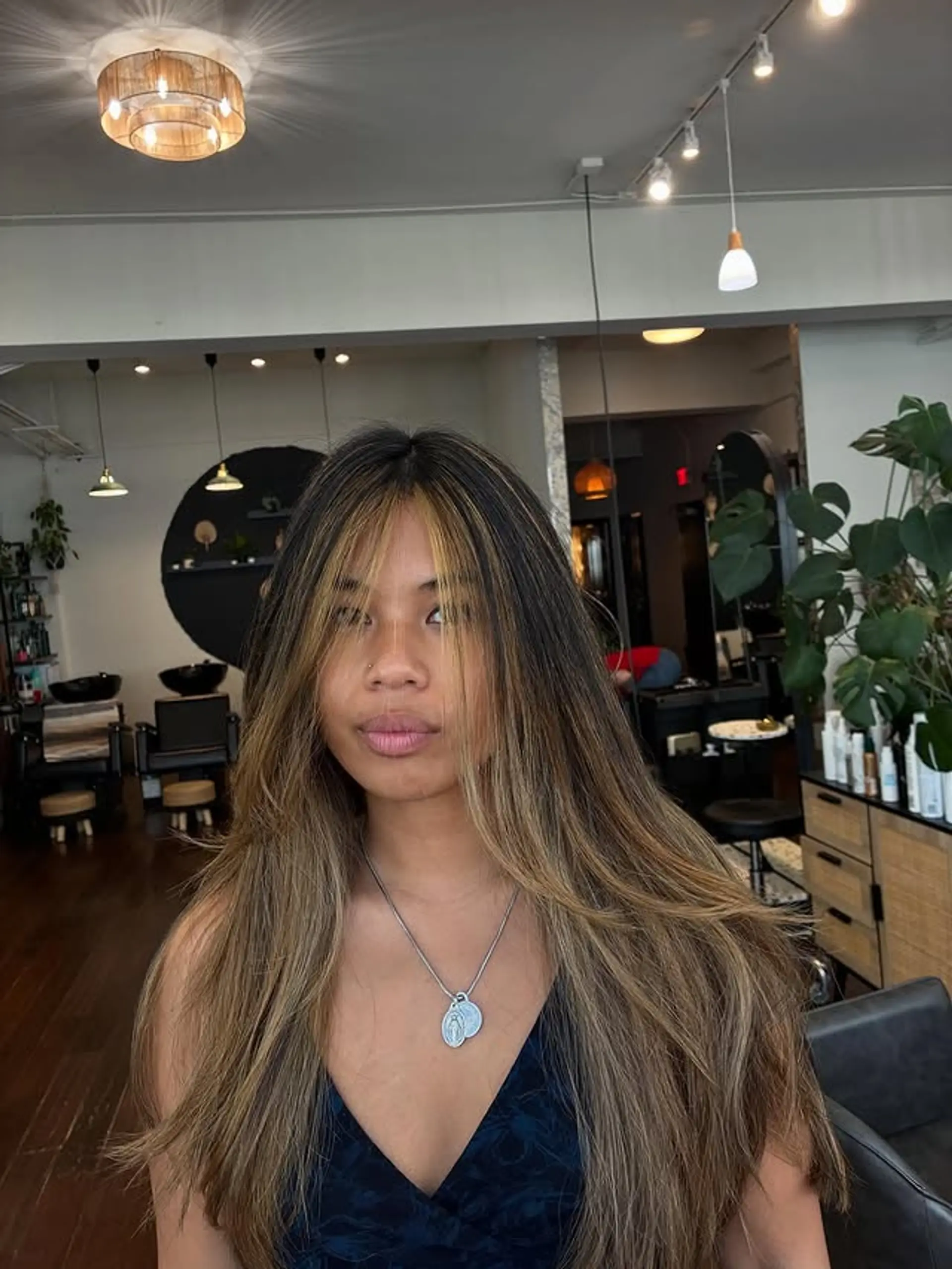 Long layered hairstyle with balayage highlights and face-framing bangs. 1