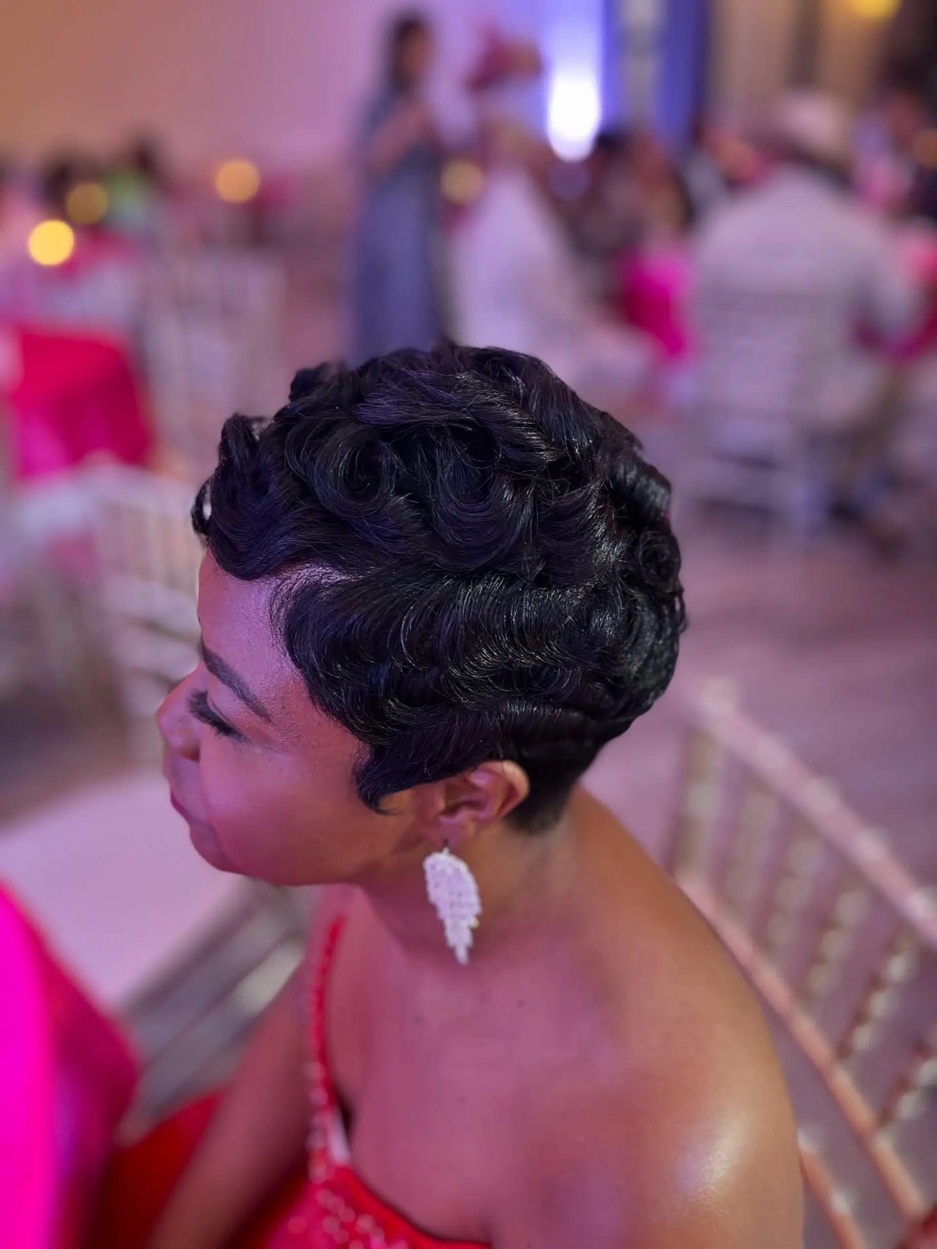 A sophisticated very short pixie cut featuring deeply defined, polished finger waves that beautifully frame the face and head, offering a timeless and elegant aesthetic. 1