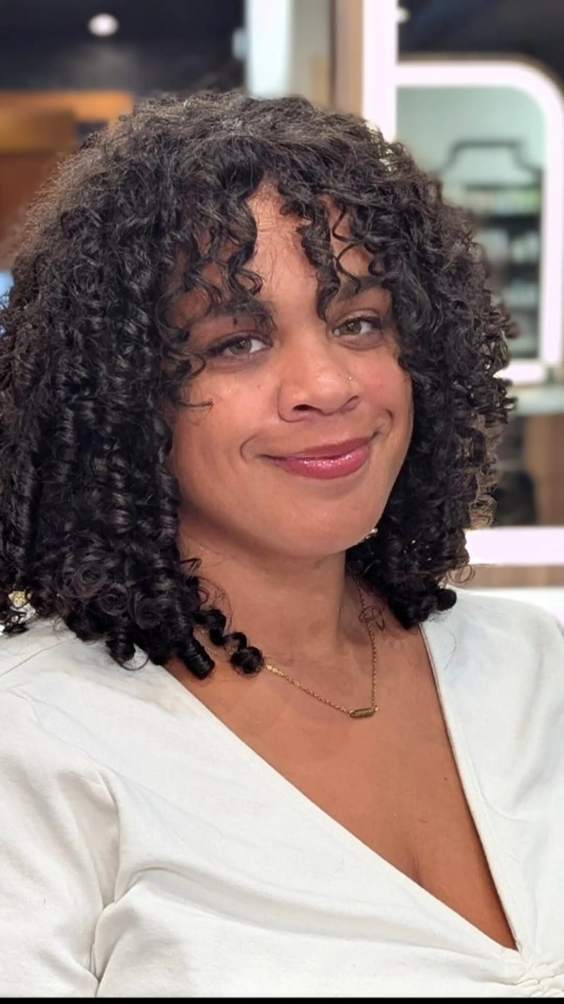 Shoulder-skimming defined curls styled with matching curly bangs in a rich dark brunette tone. 1