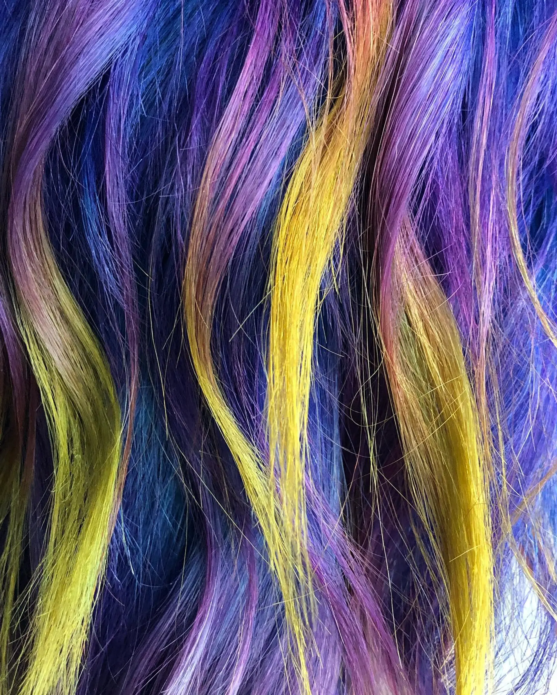 A wavy lob haircut with a vibrant rainbow of colors achieved through balayage. 2