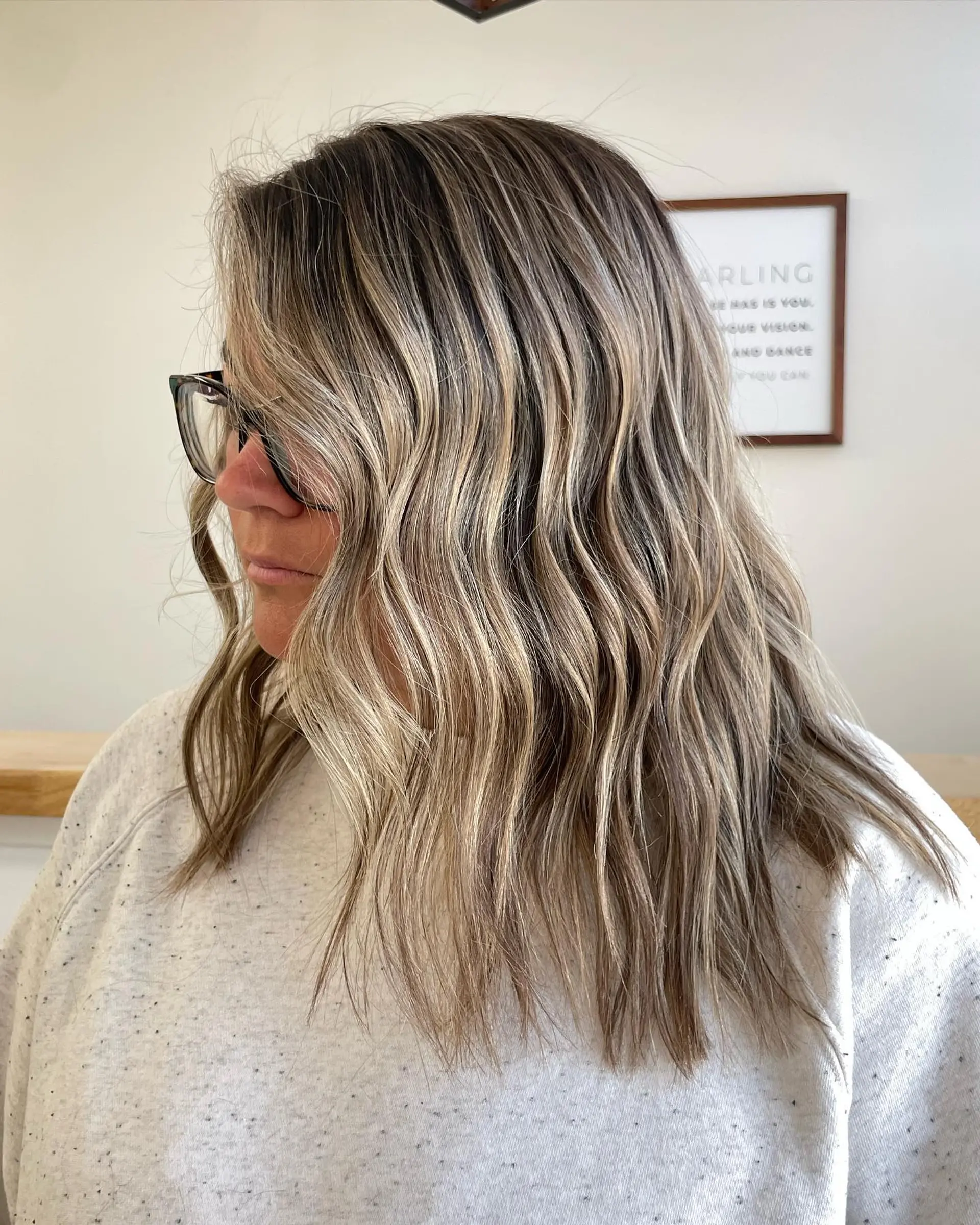 Shoulder-length brunette hair styled with loose textured waves and cool ash blonde balayage highlights. 1