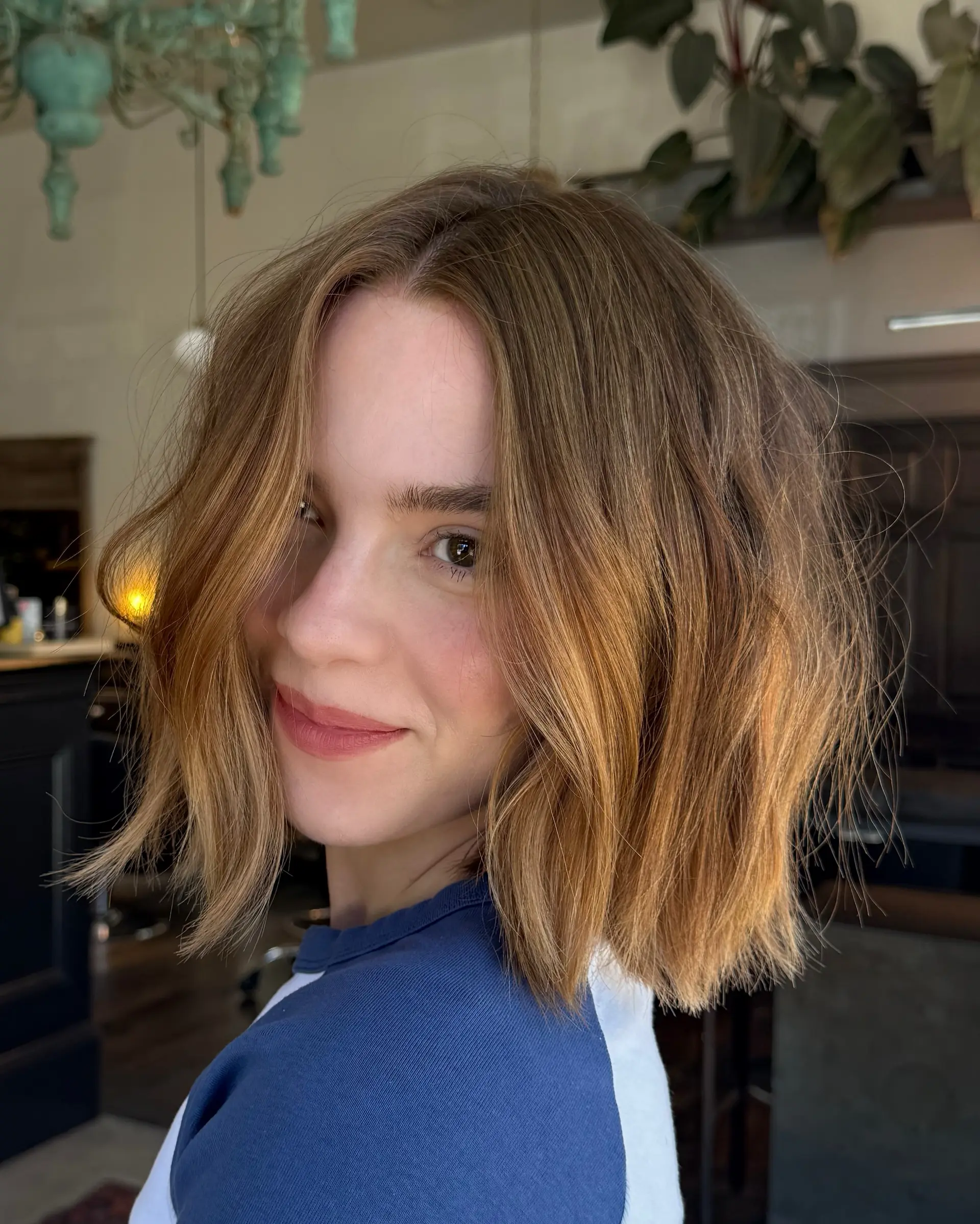A textured chin-to-collarbone bob haircut styled with subtle undone waves and warm golden caramel tones. 1
