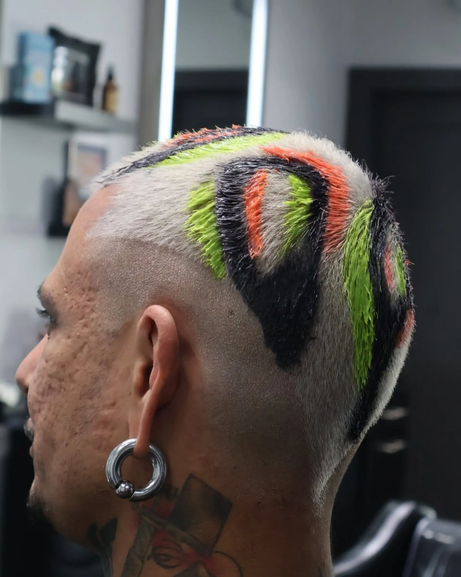 A buzzcut with color block sections of black, orange, and green. 2