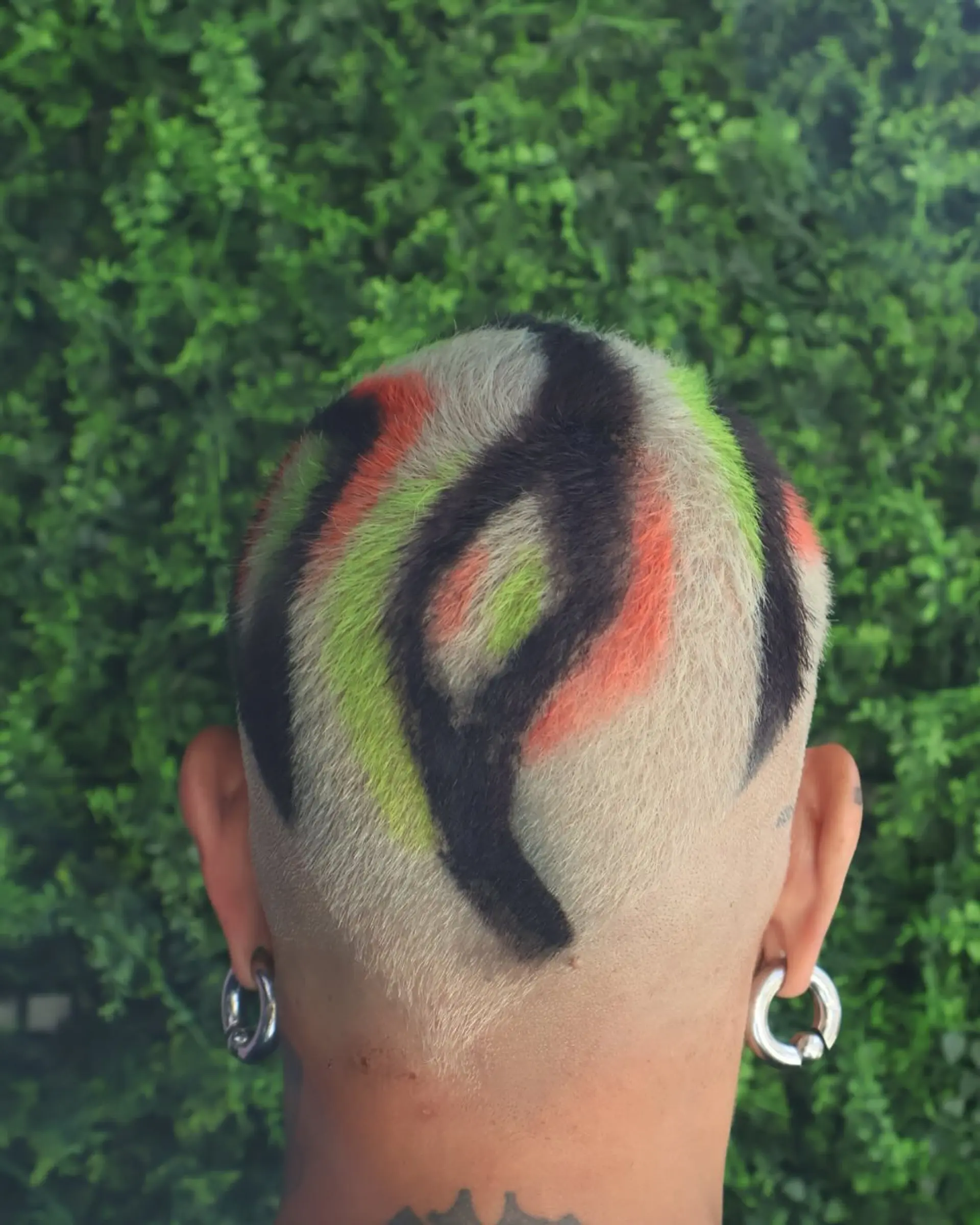 A buzzcut with color block sections of black, orange, and green. 3