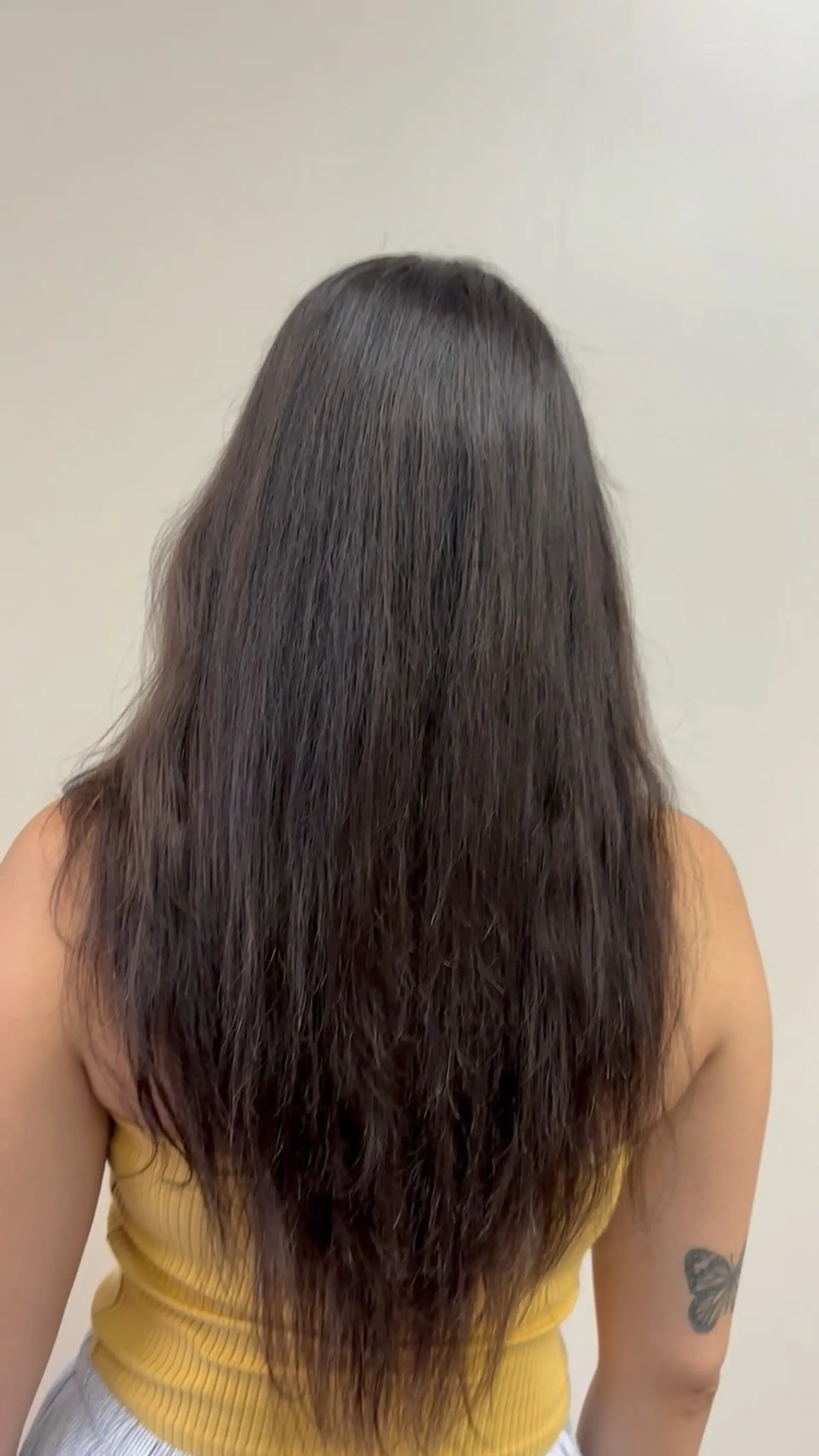 Long, dark brown hair enhanced with seamless extensions tapering into a textured V-shape at the ends. 1