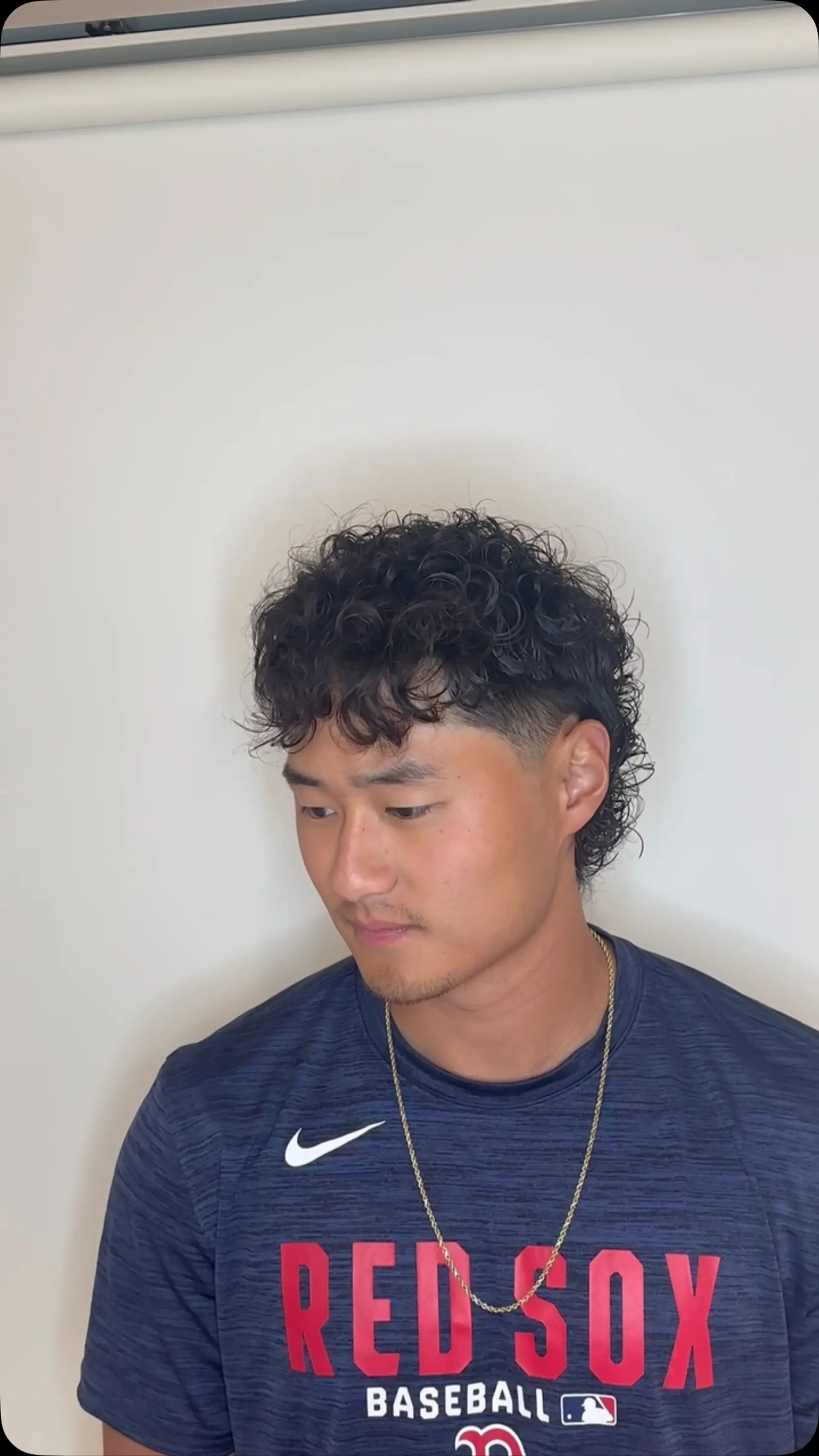A textured curly perm paired with a modern mullet cut and tapered sides. 1