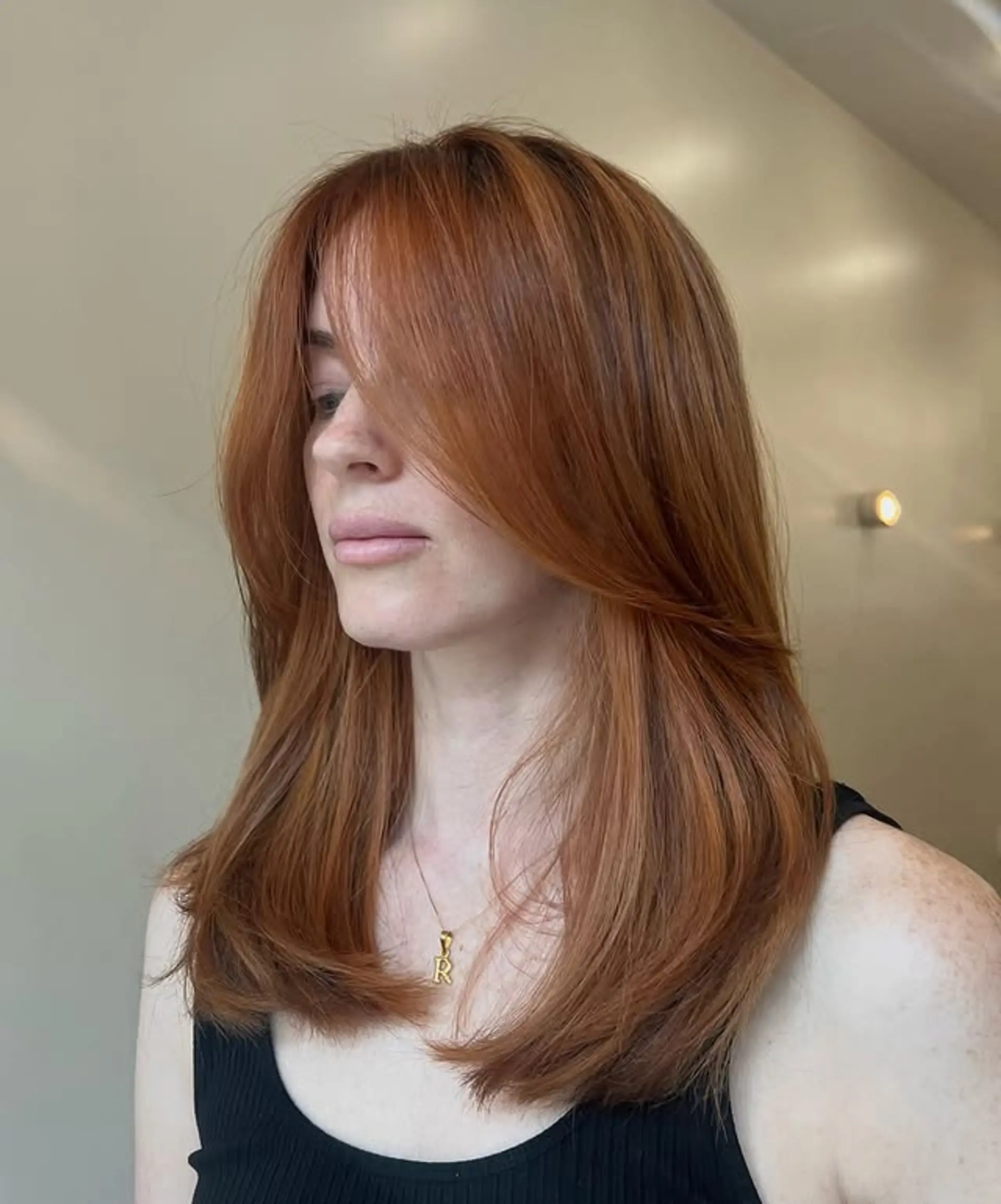 A layered hairstyle with face-framing Bardot bangs. 1