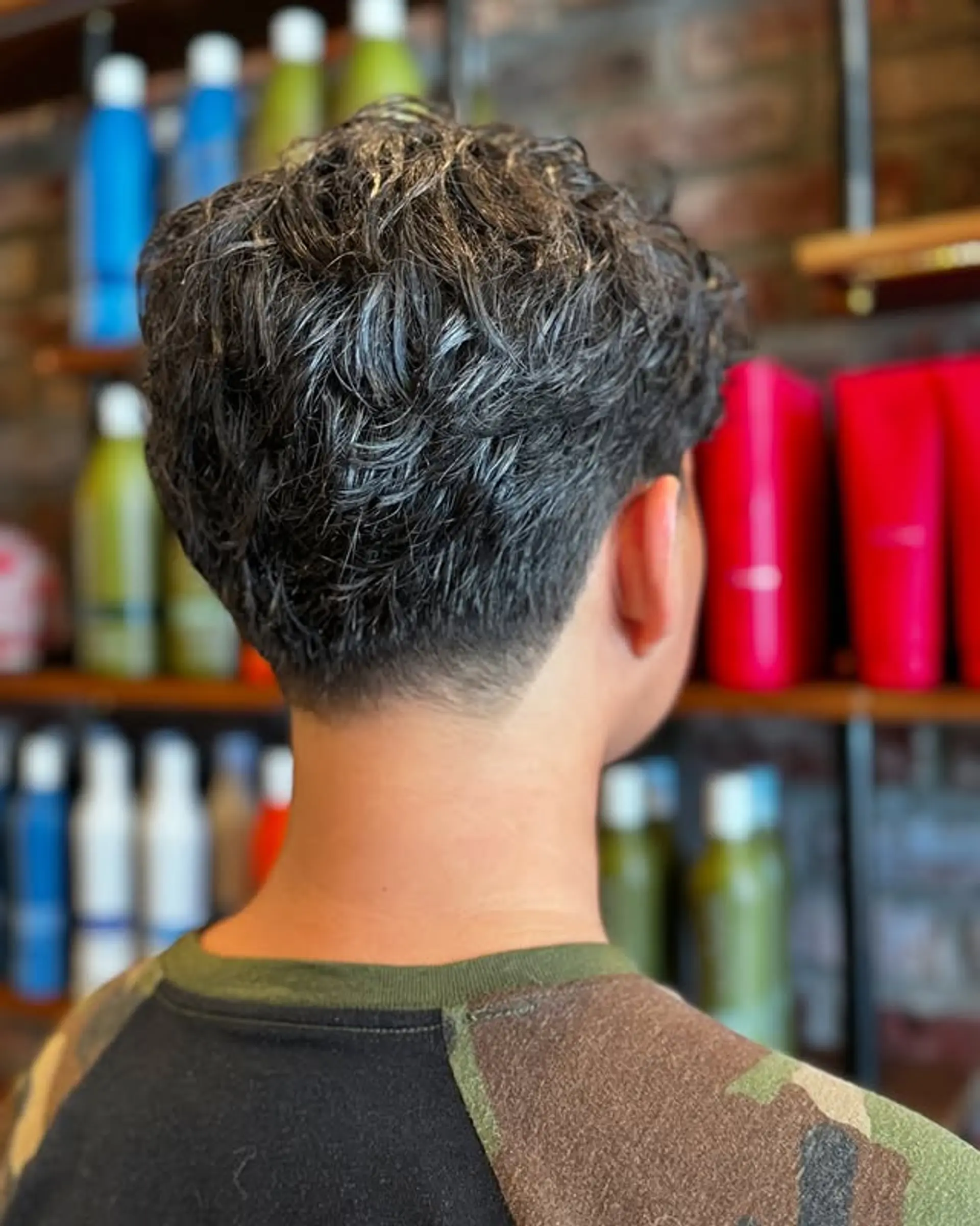 A short, textured crop on top with a low taper fade around the sides and back. 1