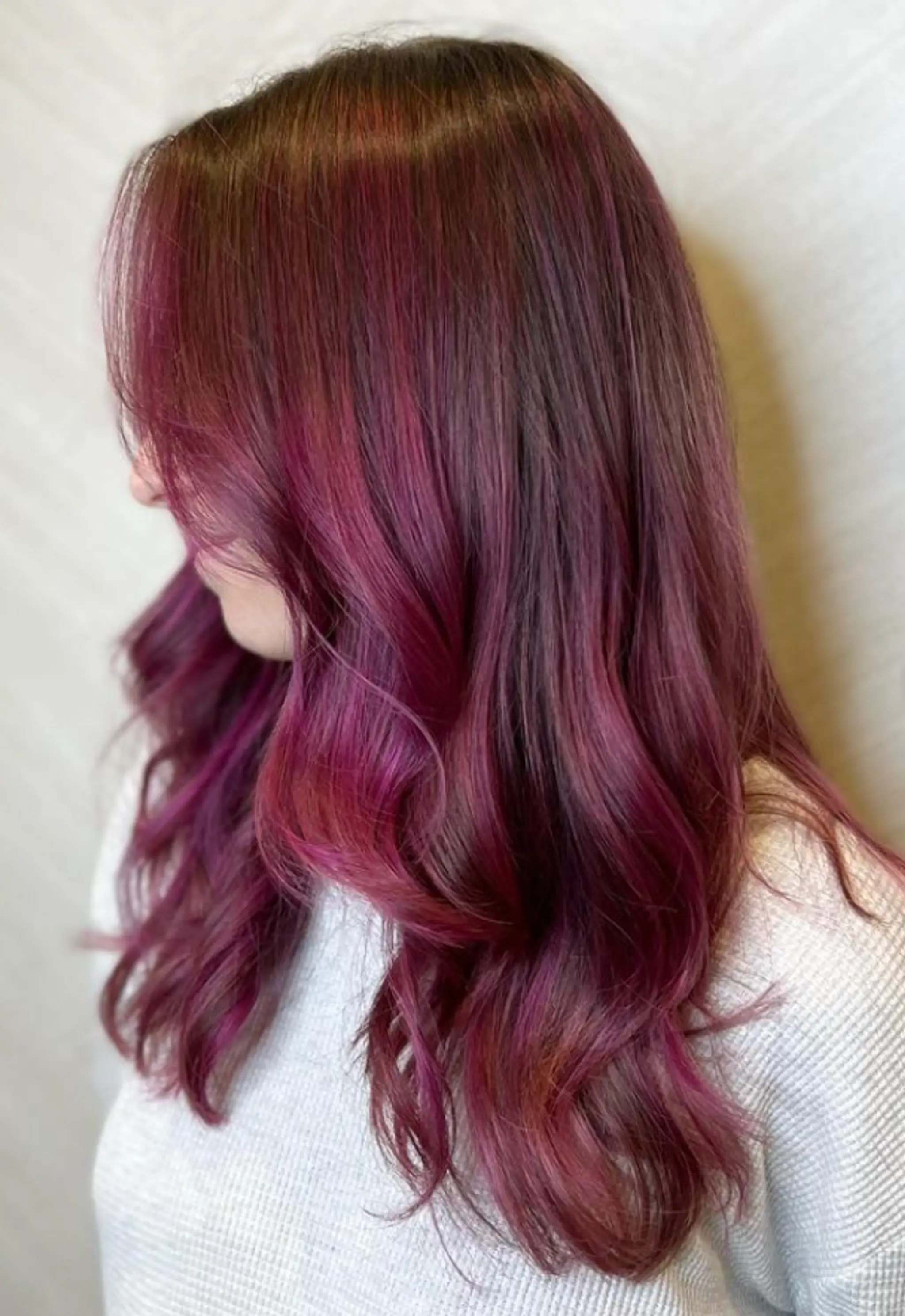 Long, wavy locks with a vibrant gradient of pink and purple colors, featuring soft waves that frame the face and a shiny finish. 2