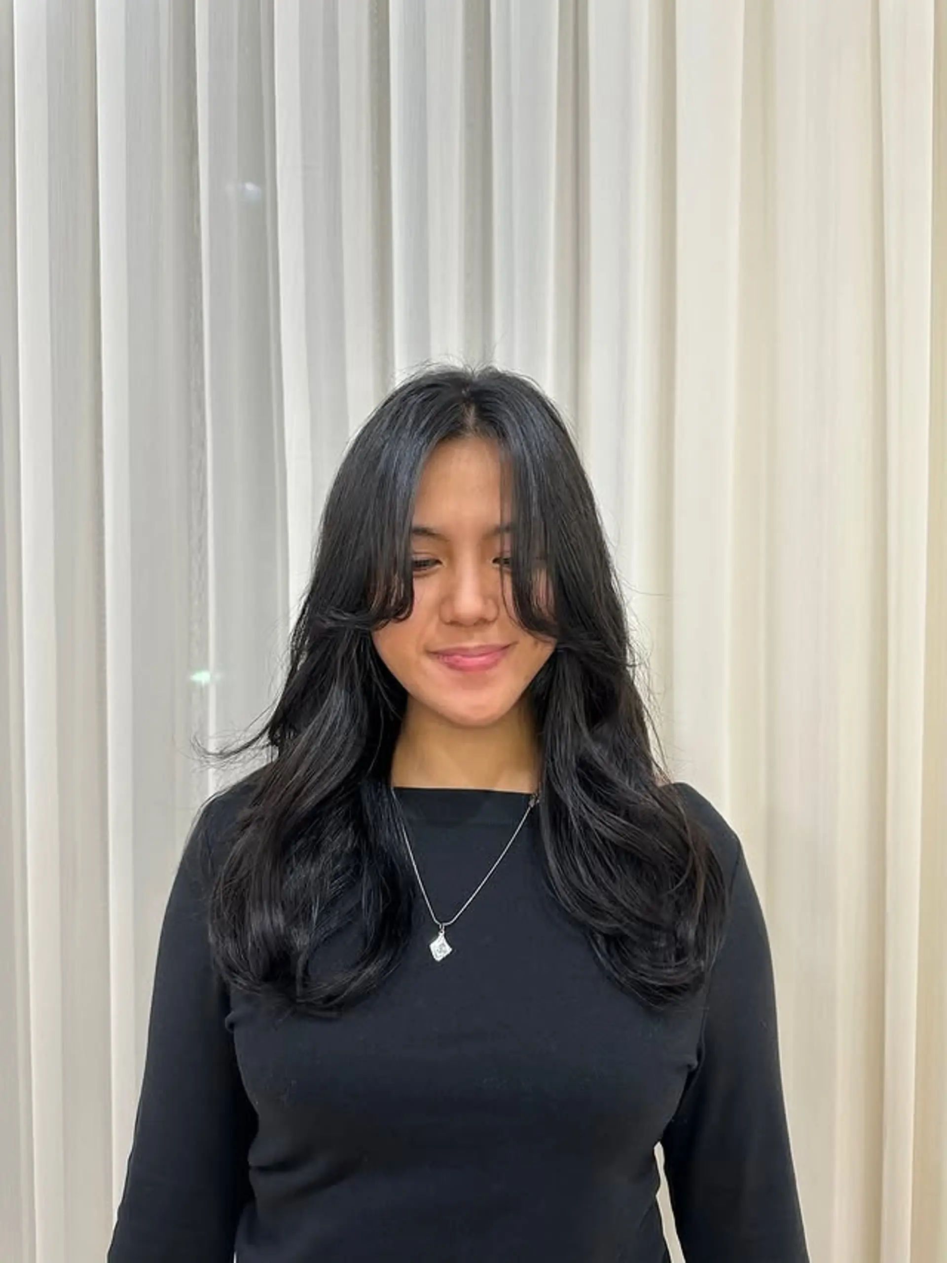 A layered long hairstyle with face-framing curtain bangs and a subtle wave. 1