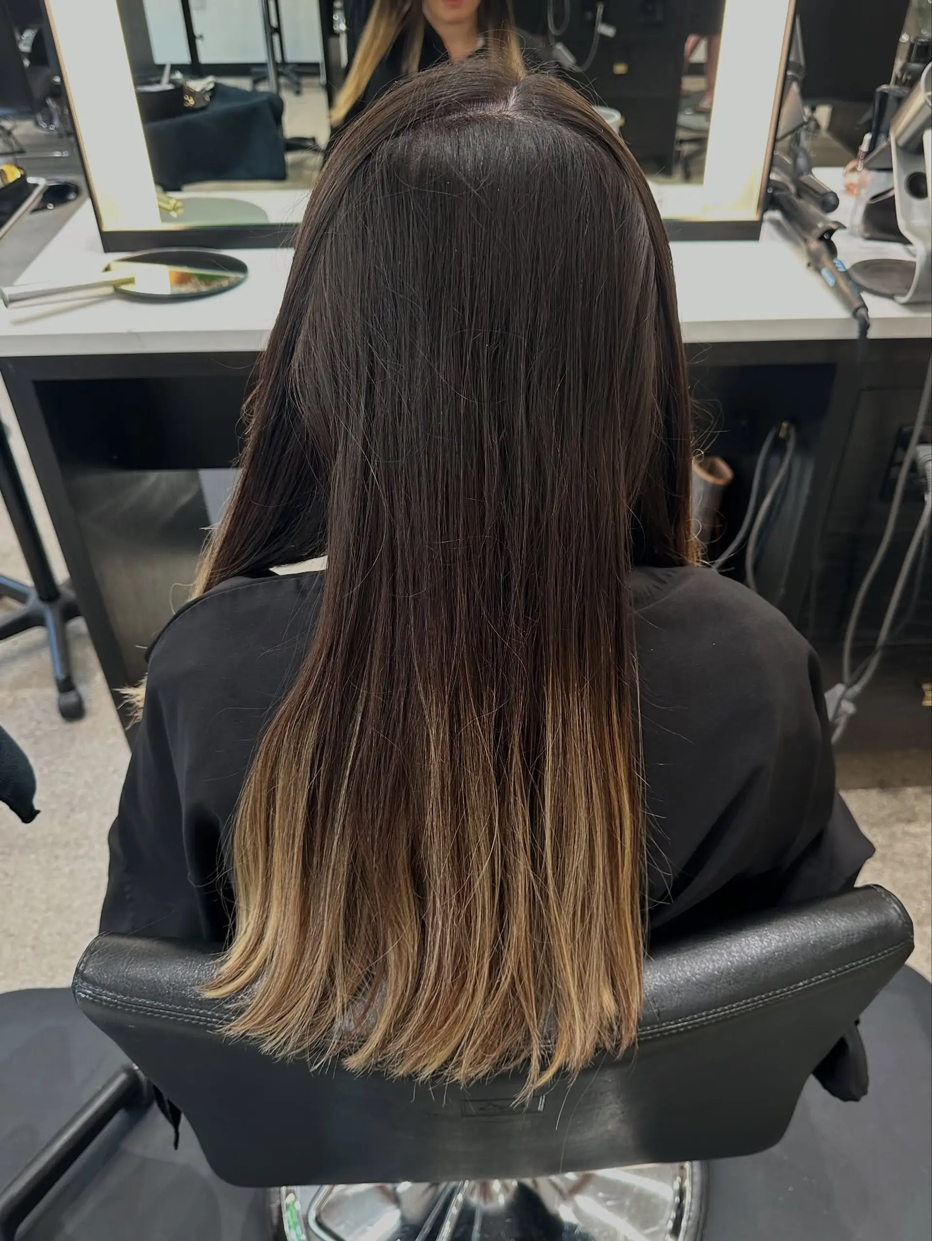 Long, wavy hair with a rooted blonde balayage. 4