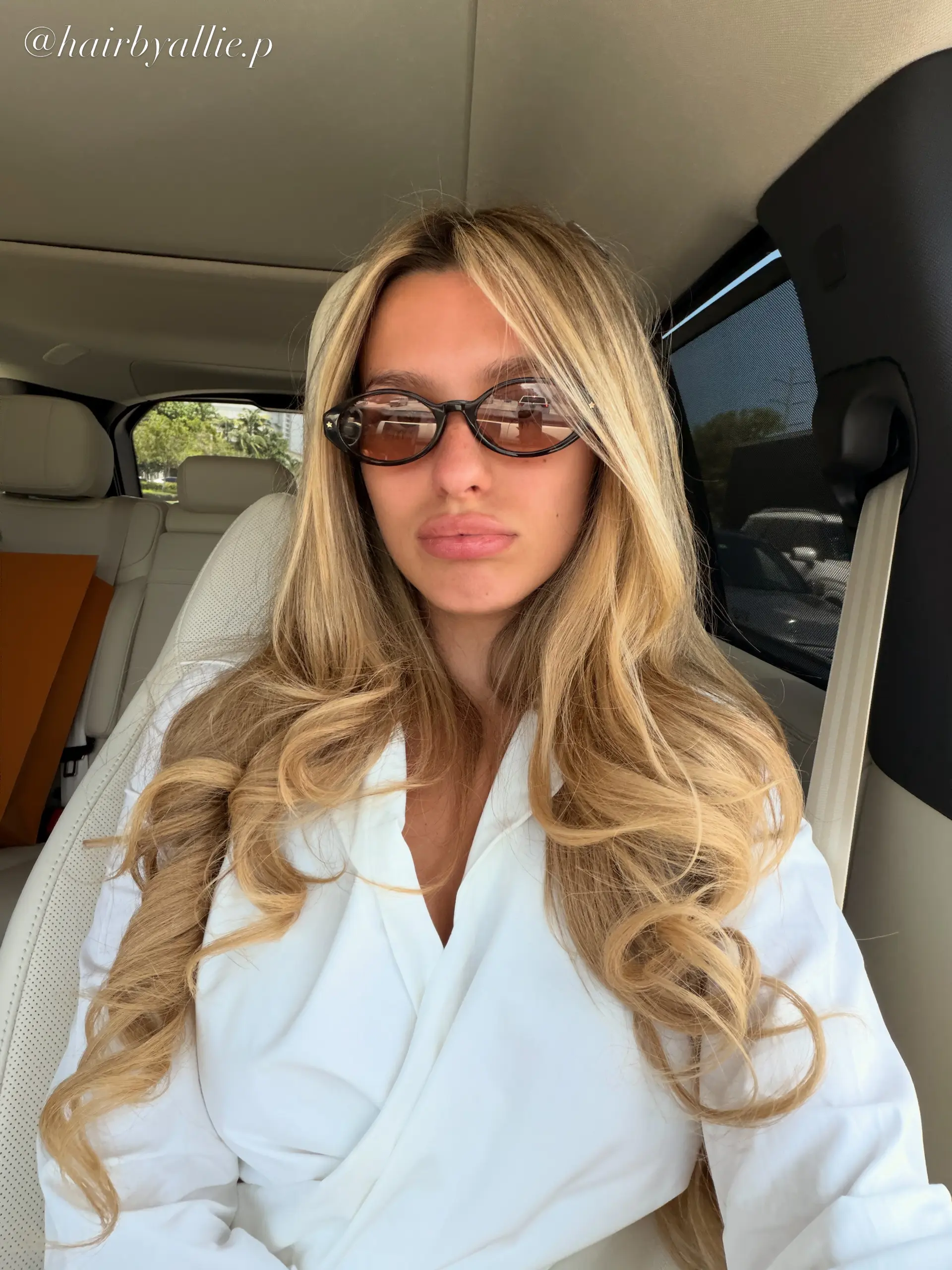 Extremely long golden blonde hair styled in voluminous, polished waves with a middle part. 1