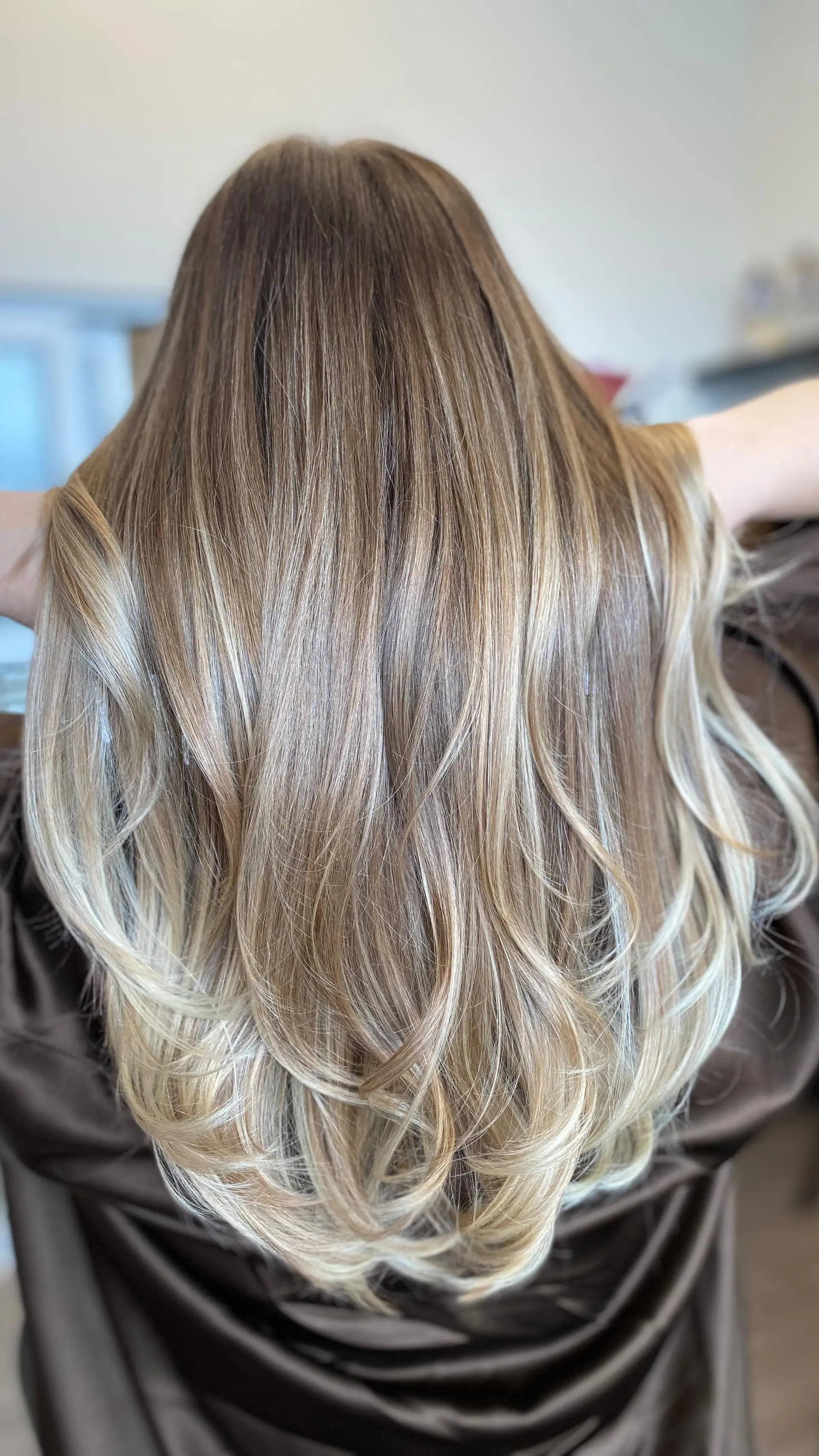 Long dimensional blonde hair cut in flowing layers with a bouncy, rounded blowout. 1