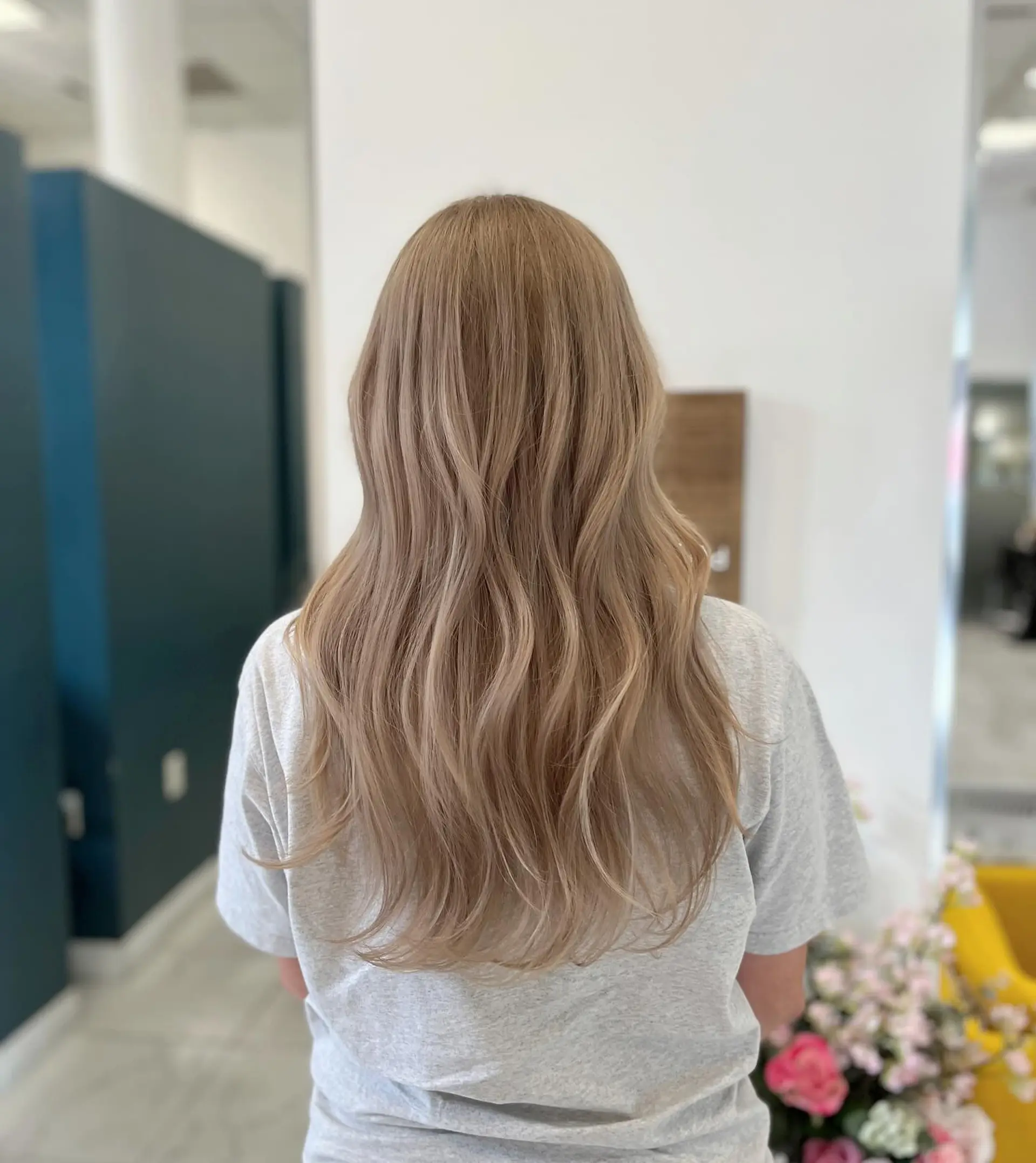 Long ash beige blonde hair styled with soft, flowing waves cascading down the back. 1