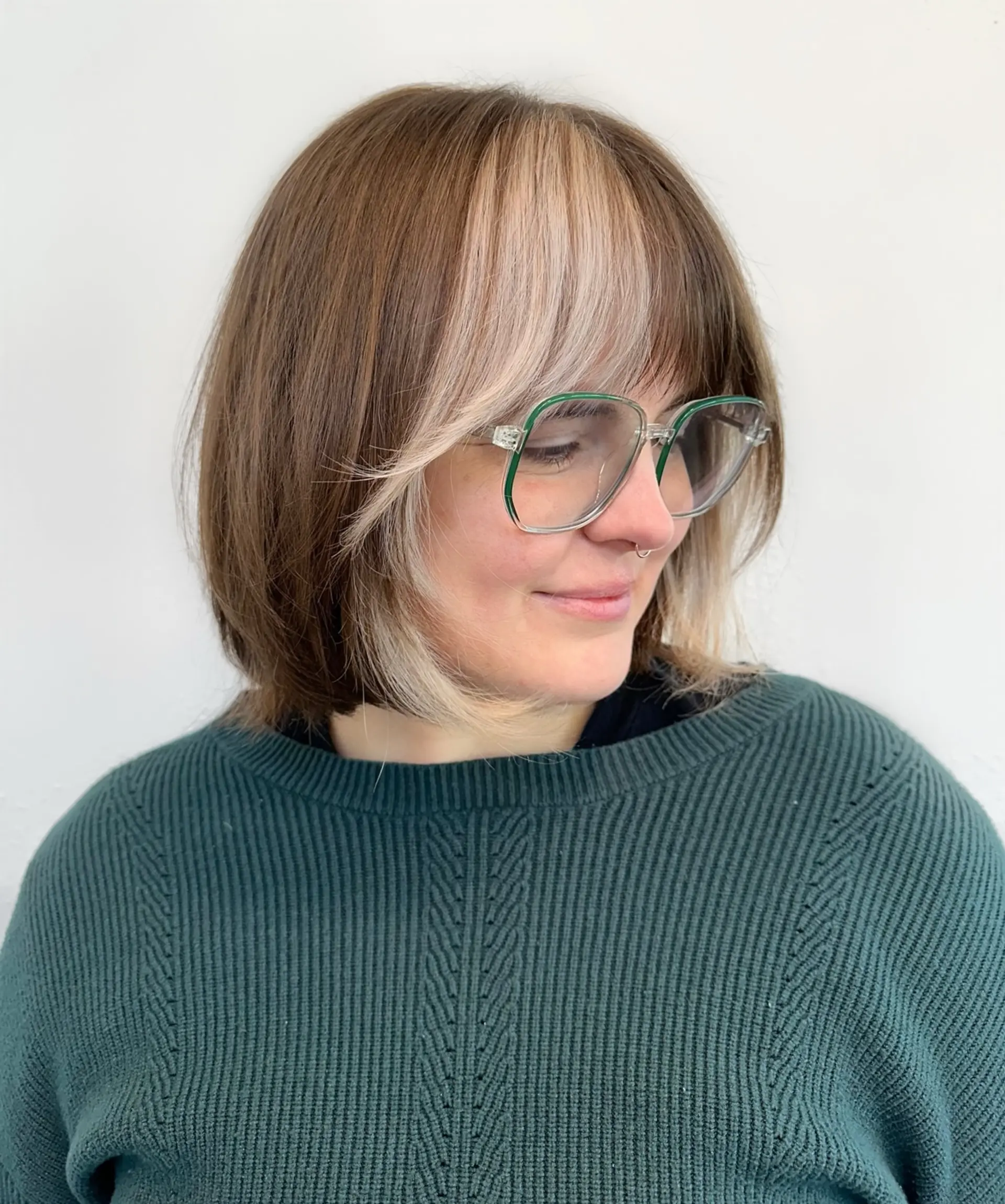 A soft chin-length bob paired with wispy fringe and a bold blonde color block at the front. 1