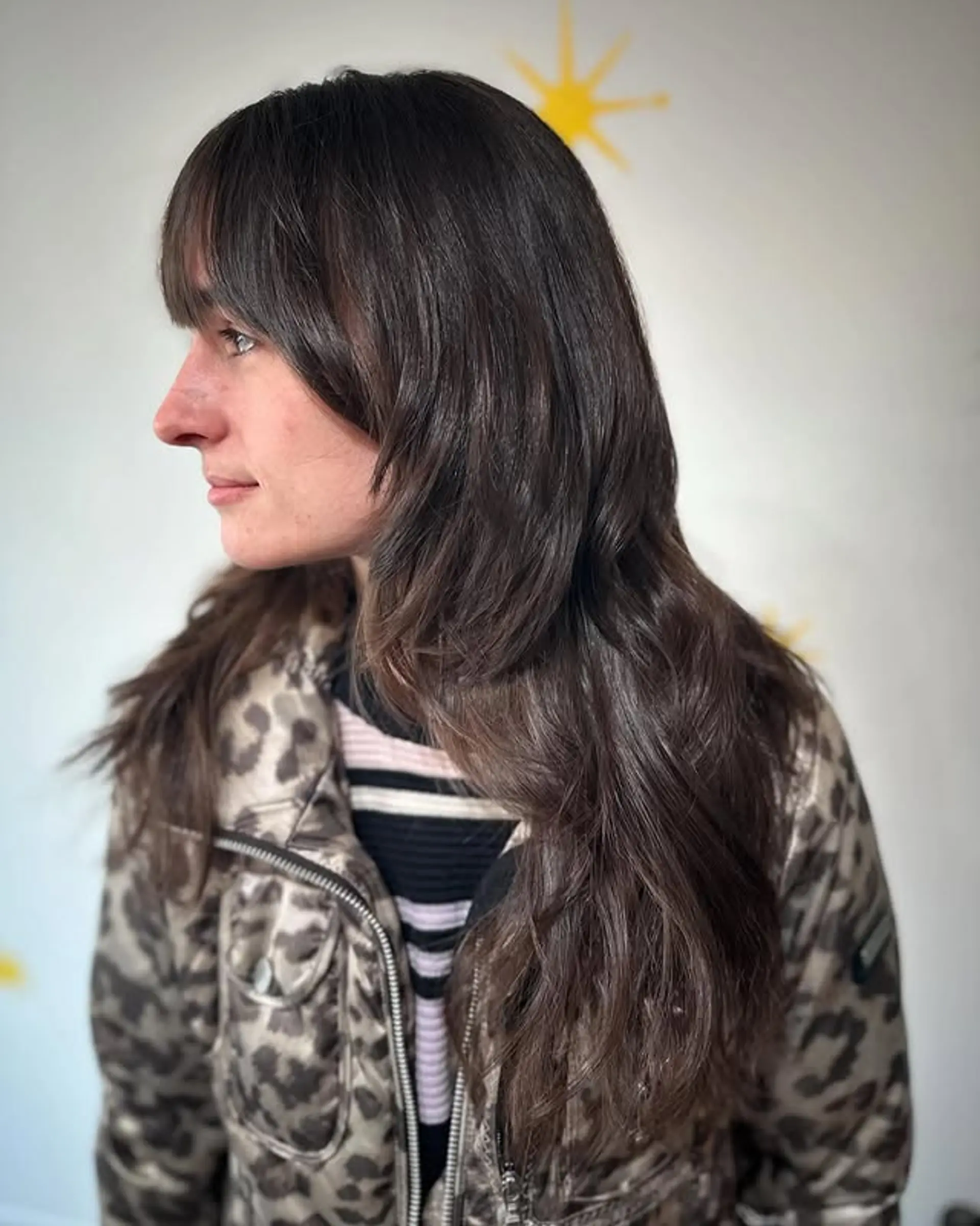 A long, layered shag haircut with curtain bangs and face-framing layers. 1