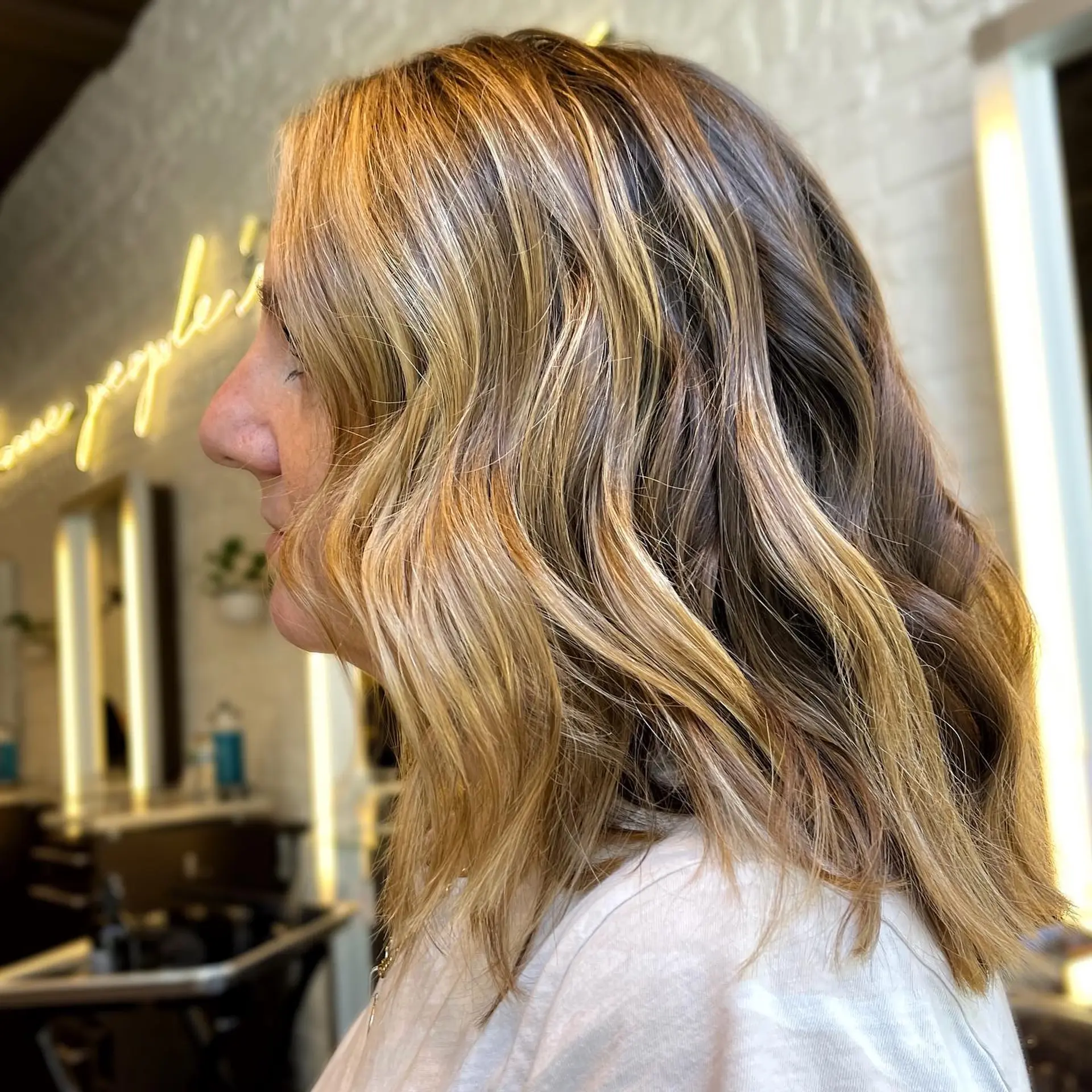 A medium-length wavy hairstyle with a bronzed balayage. 1