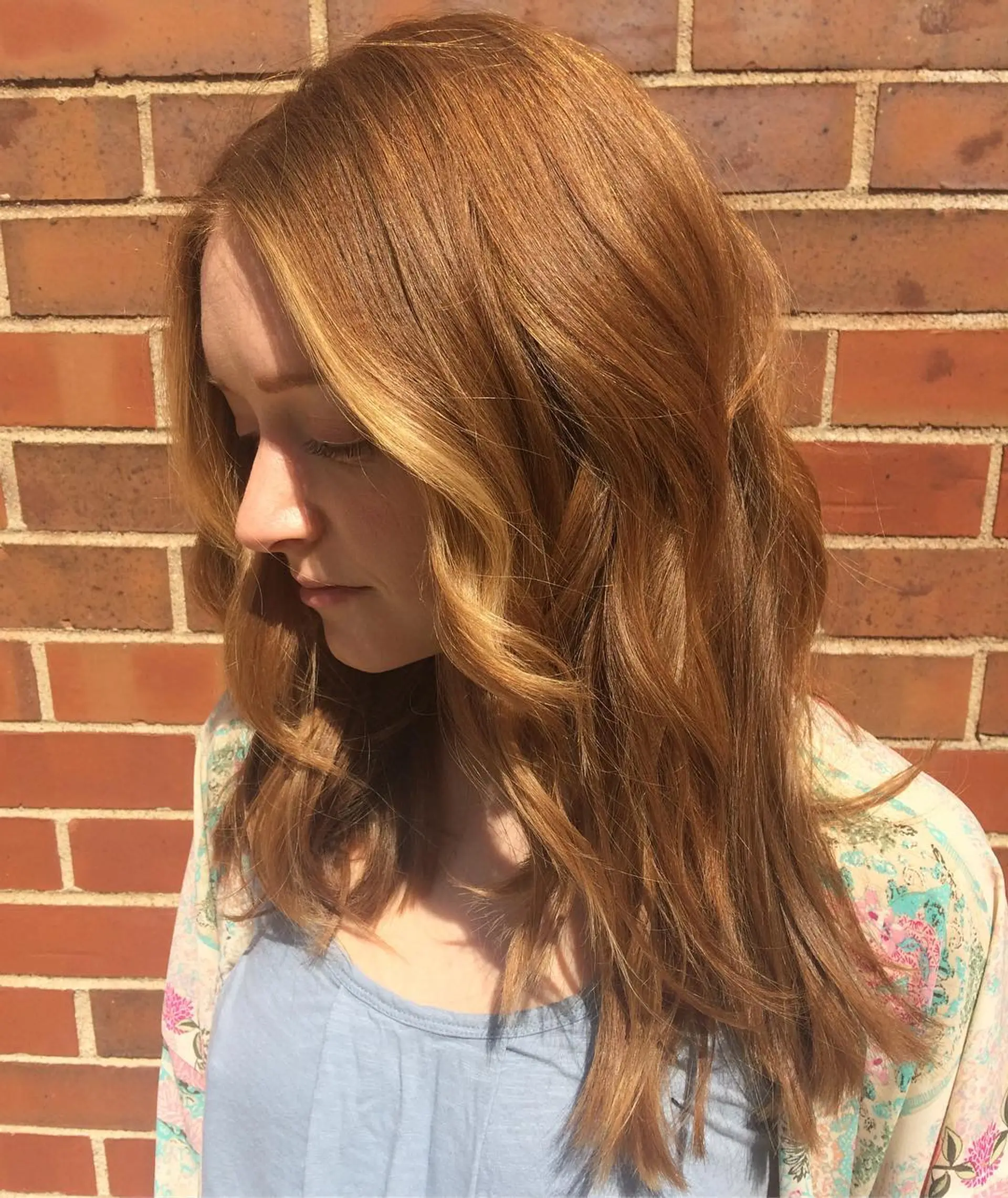A stunning medium-length hairstyle with waves and copper red hair color featuring blonde balayage highlights. 1