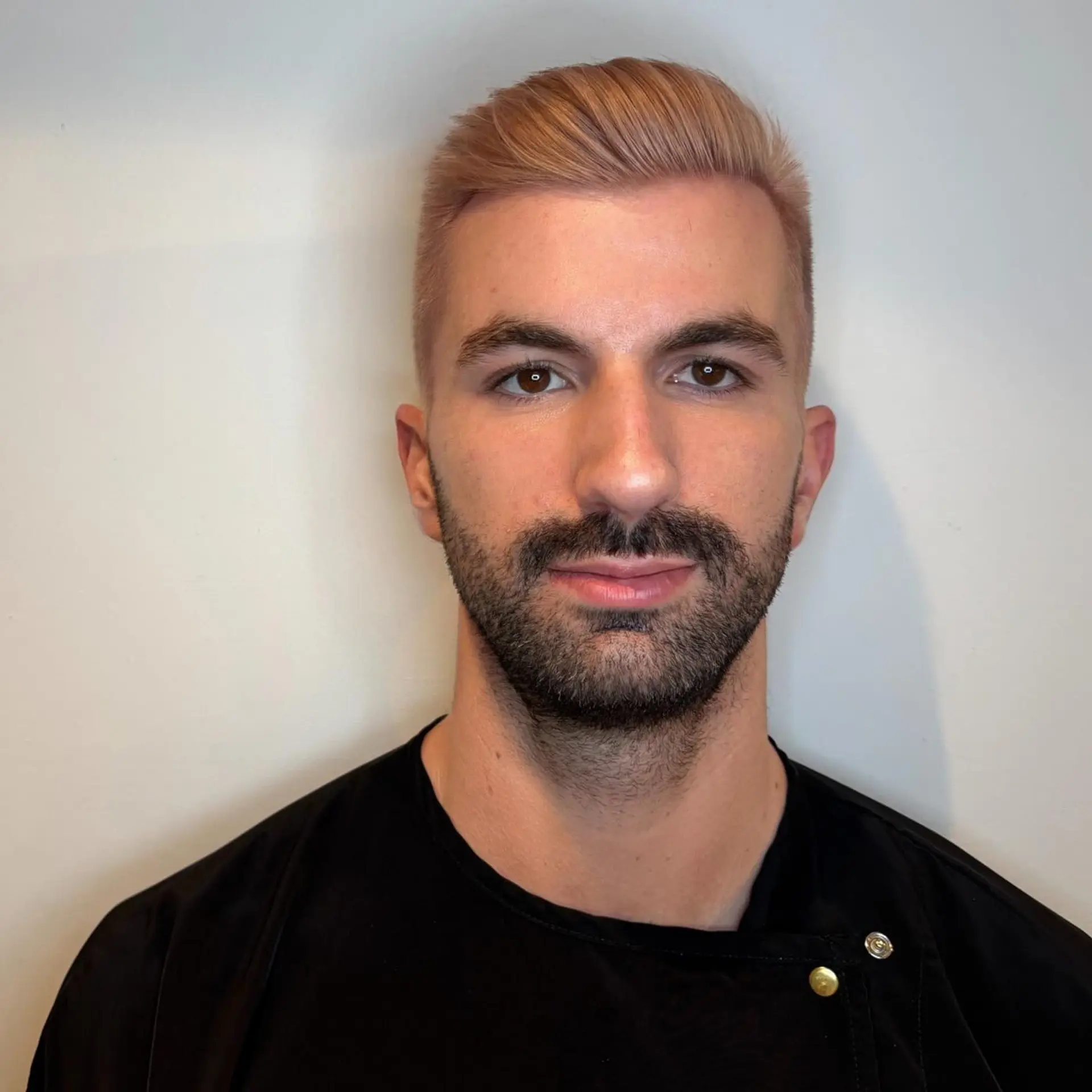 A short, clean cut styled neatly to the side and colored in a soft pastel rose gold hue. 1