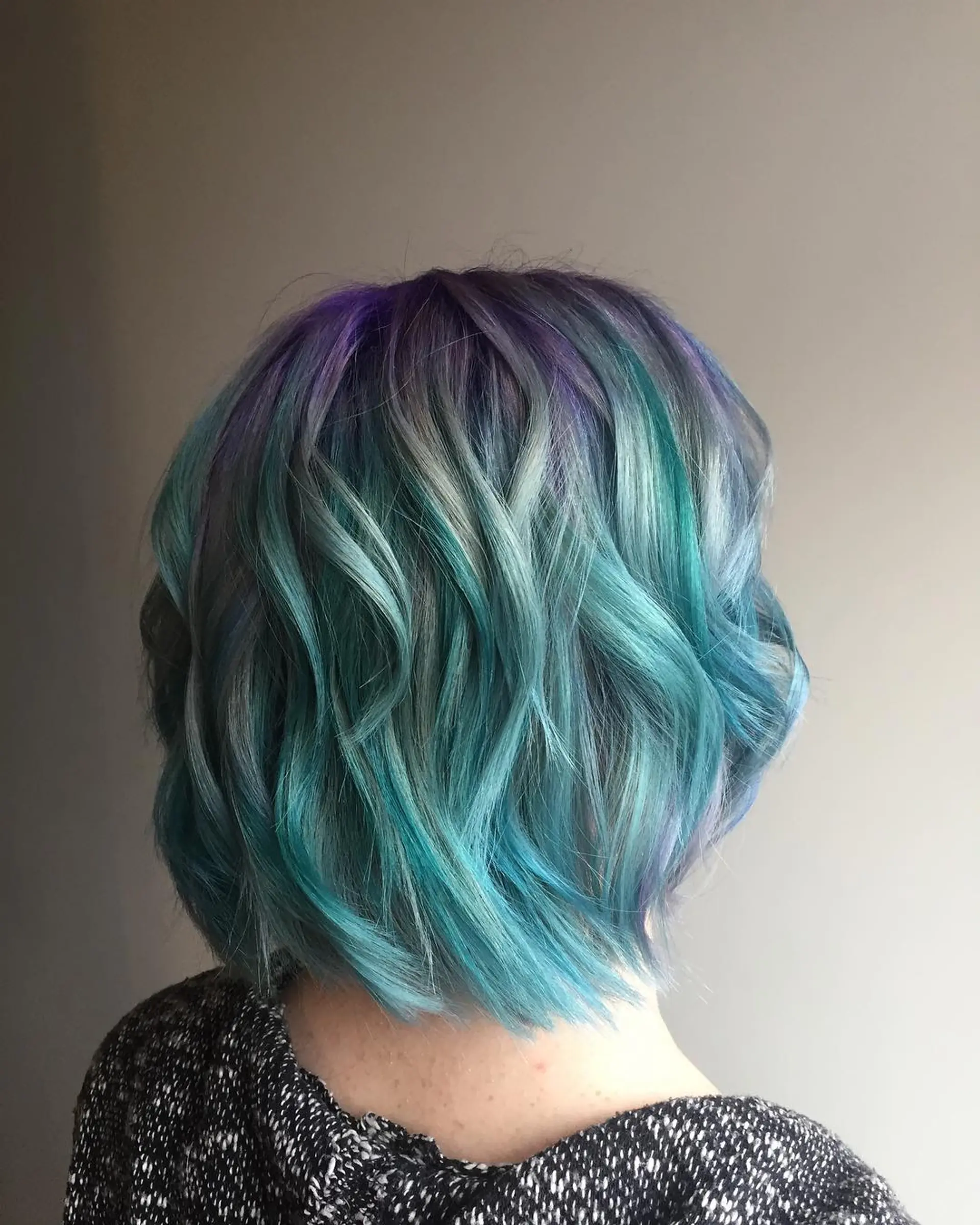 A wavy bob with a vibrant iridescent color palette, featuring turquoise, purple, and silver hues. 1