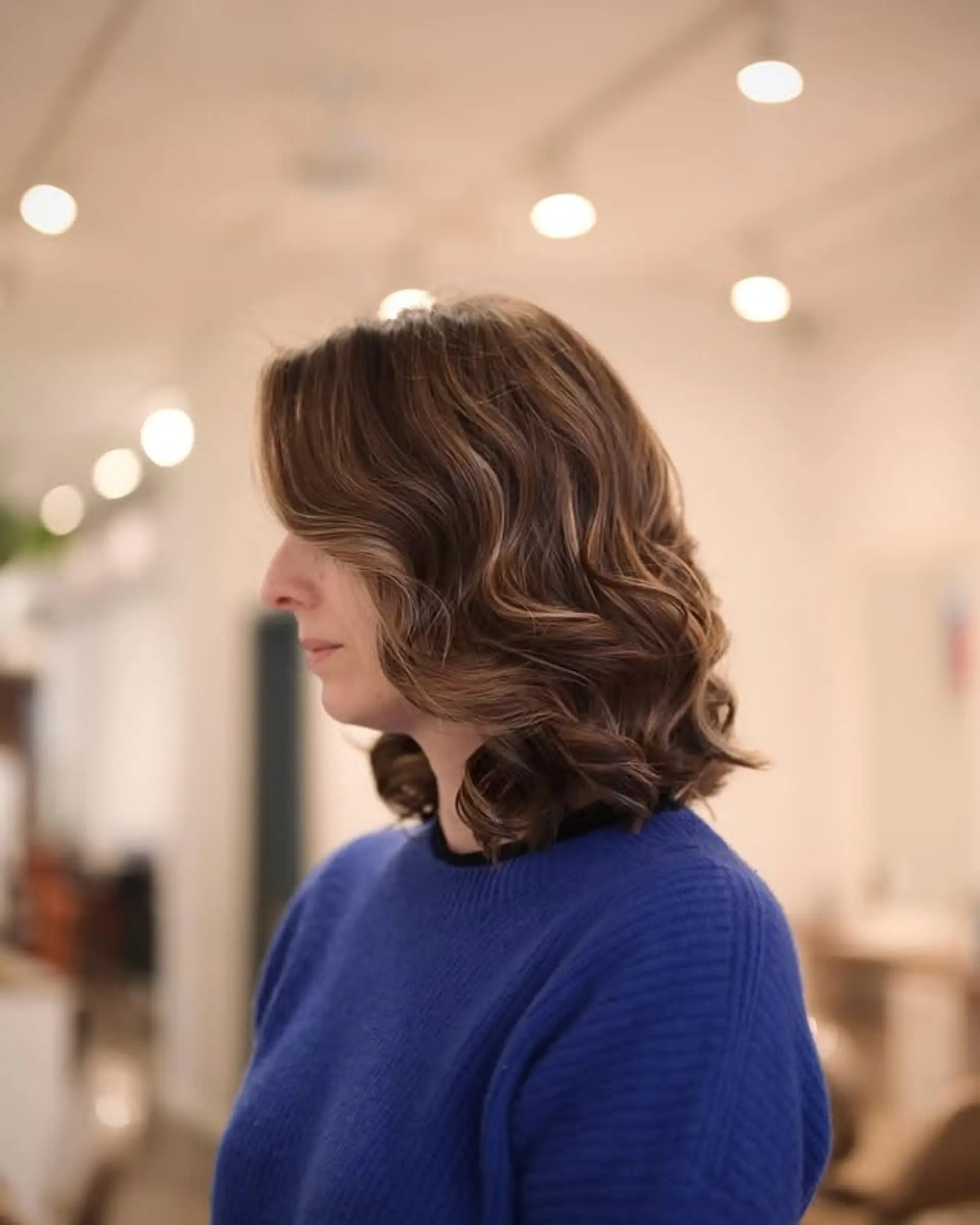 A layered lob with soft waves and a mix of brown and blonde tones, creating a bronde effect. 1