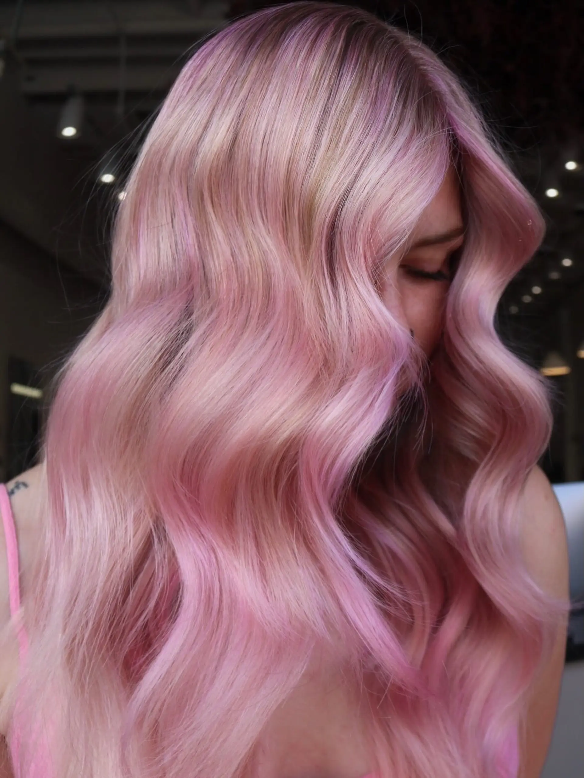 Pastel baby pink hair styled in soft, glossy body waves. 1