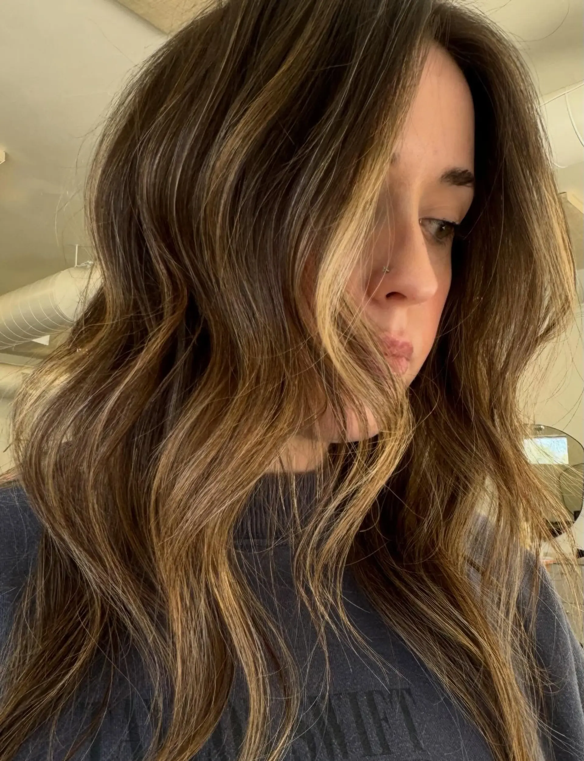 Long wavy brunette hair enhanced with dimensional honey and caramel highlights and bright face-framing pieces. 1
