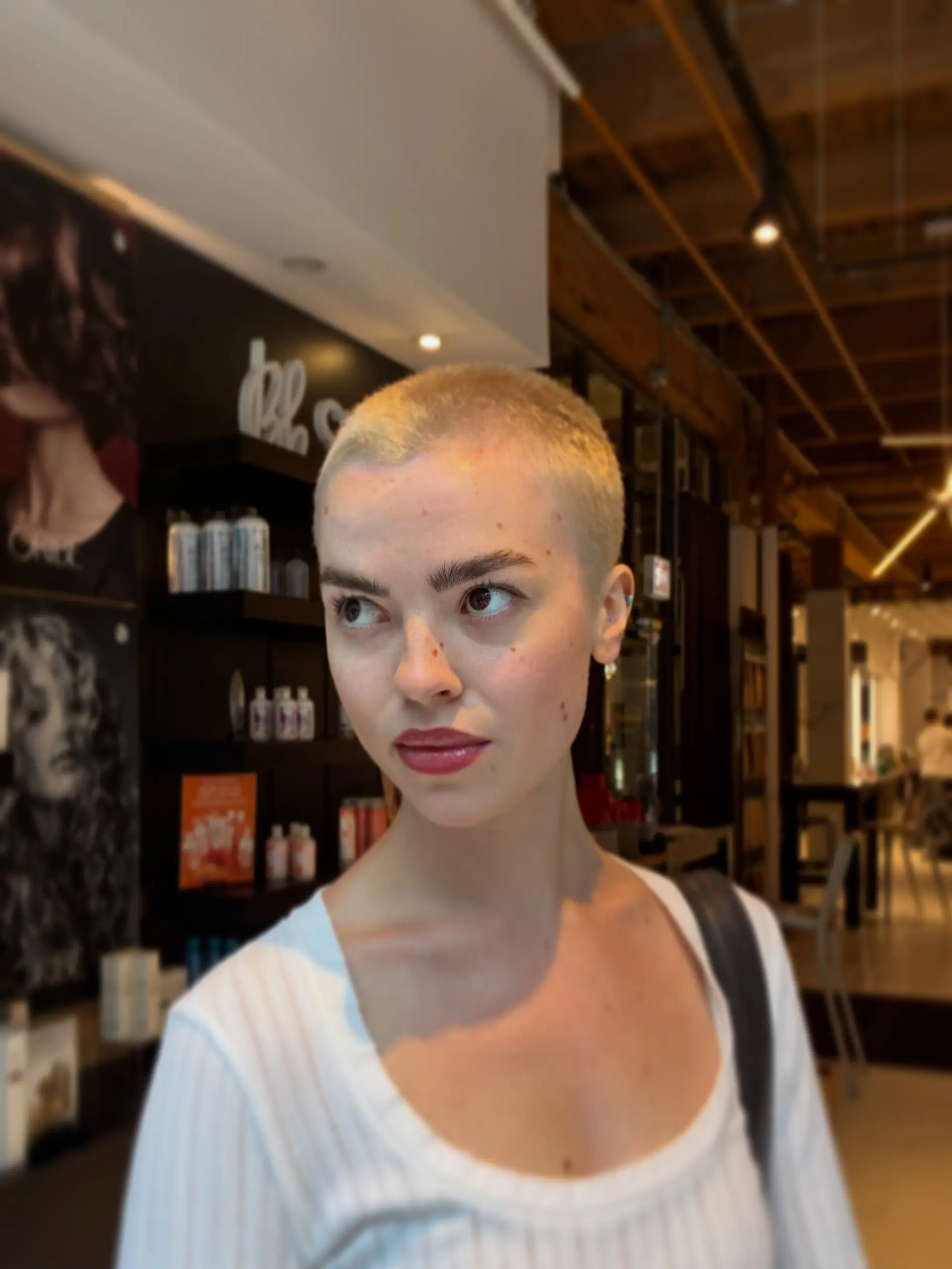 An ultra-short, even buzz cut lightened to an all-over bright platinum blonde. 1