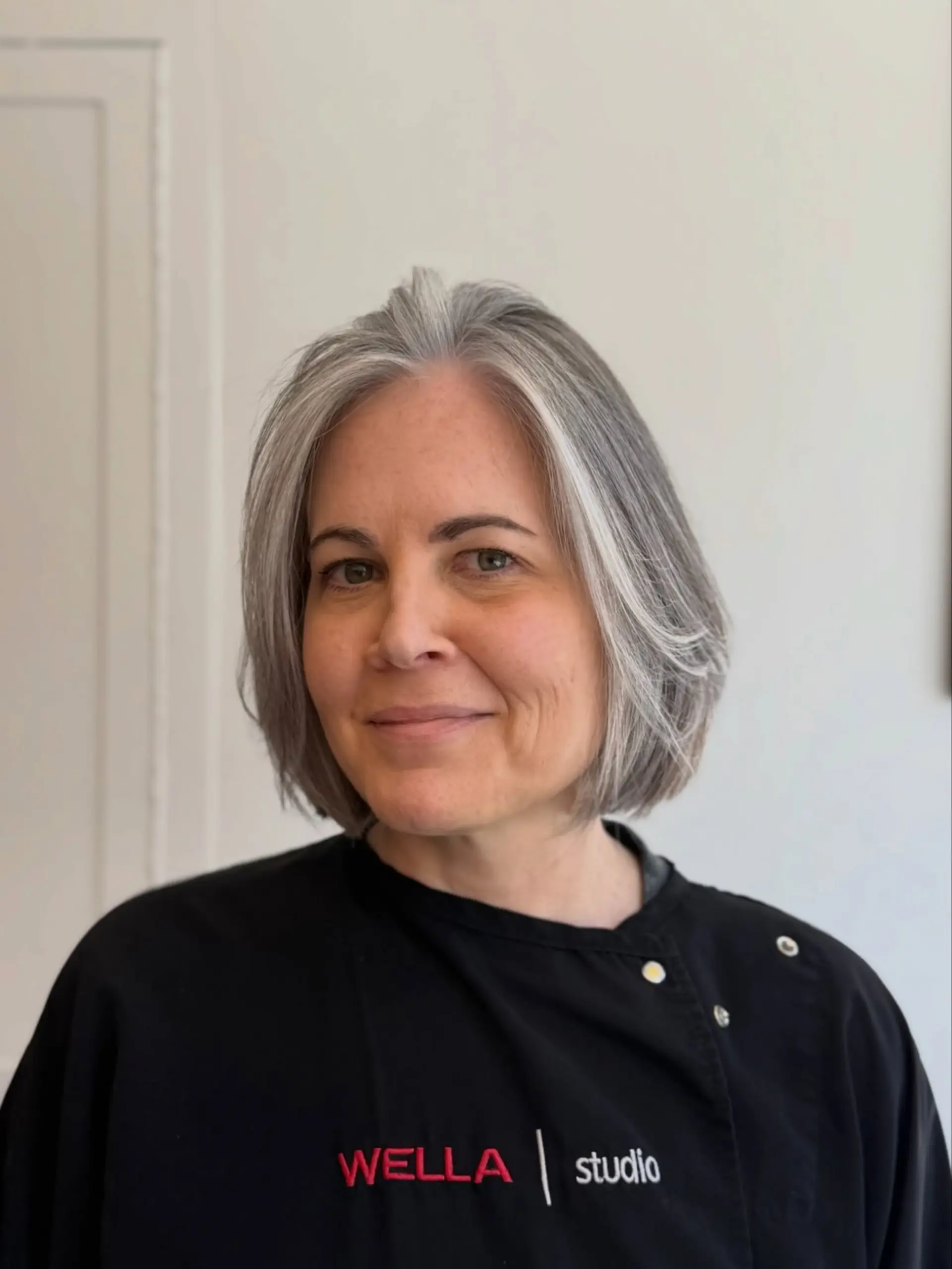 A sleek, chin-length grey bob haircut with soft face-framing layers. 1