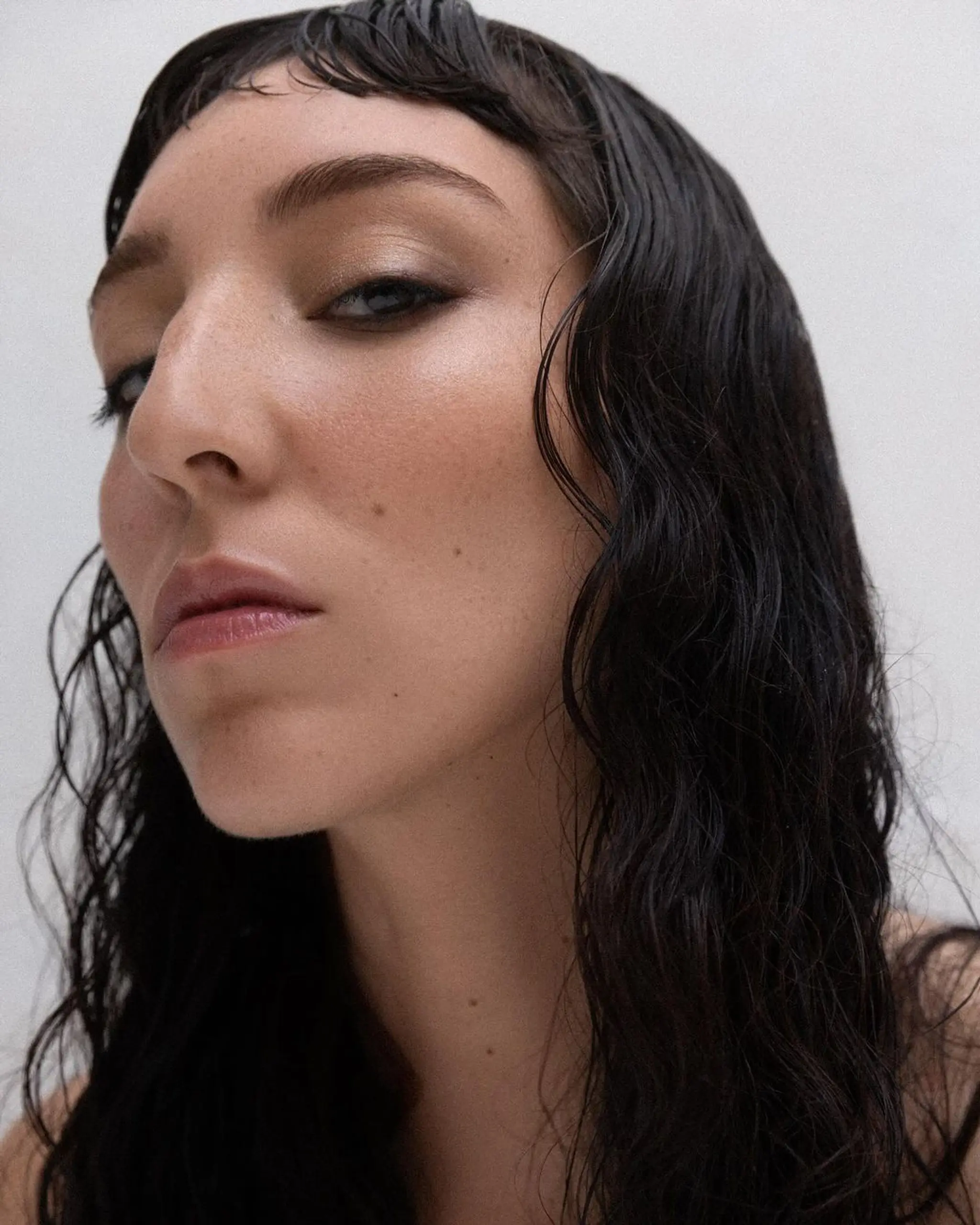 Medium-length wavy hairstyle with a wet, glossy texture. Features side-swept bangs and naturally styled waves in a sleek black color. Bangs by @takeohair 1