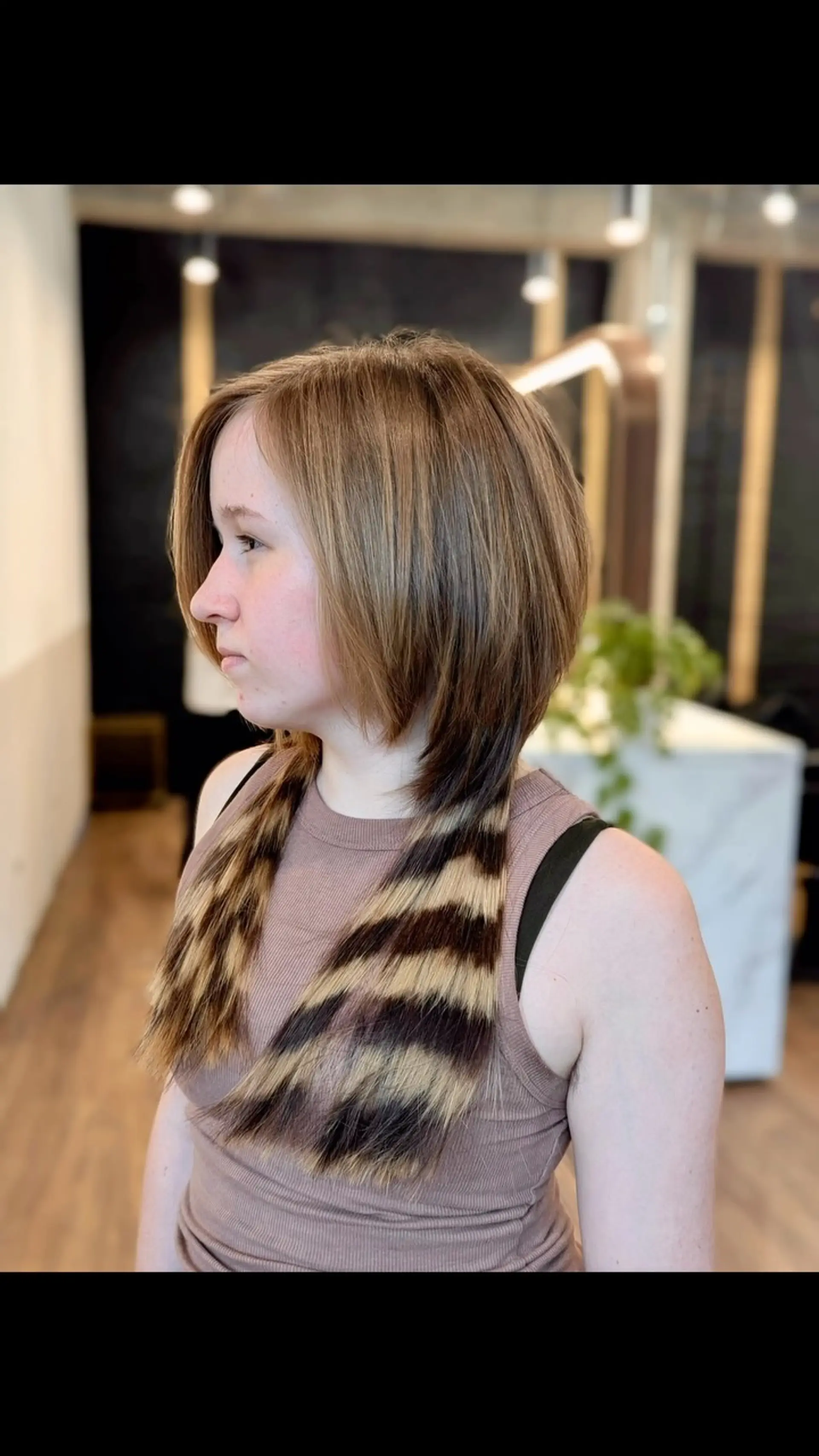 A disconnected jellyfish haircut styled smooth with Y2K-inspired horizontal raccoon tail stripes on the longer bottom layer. 1