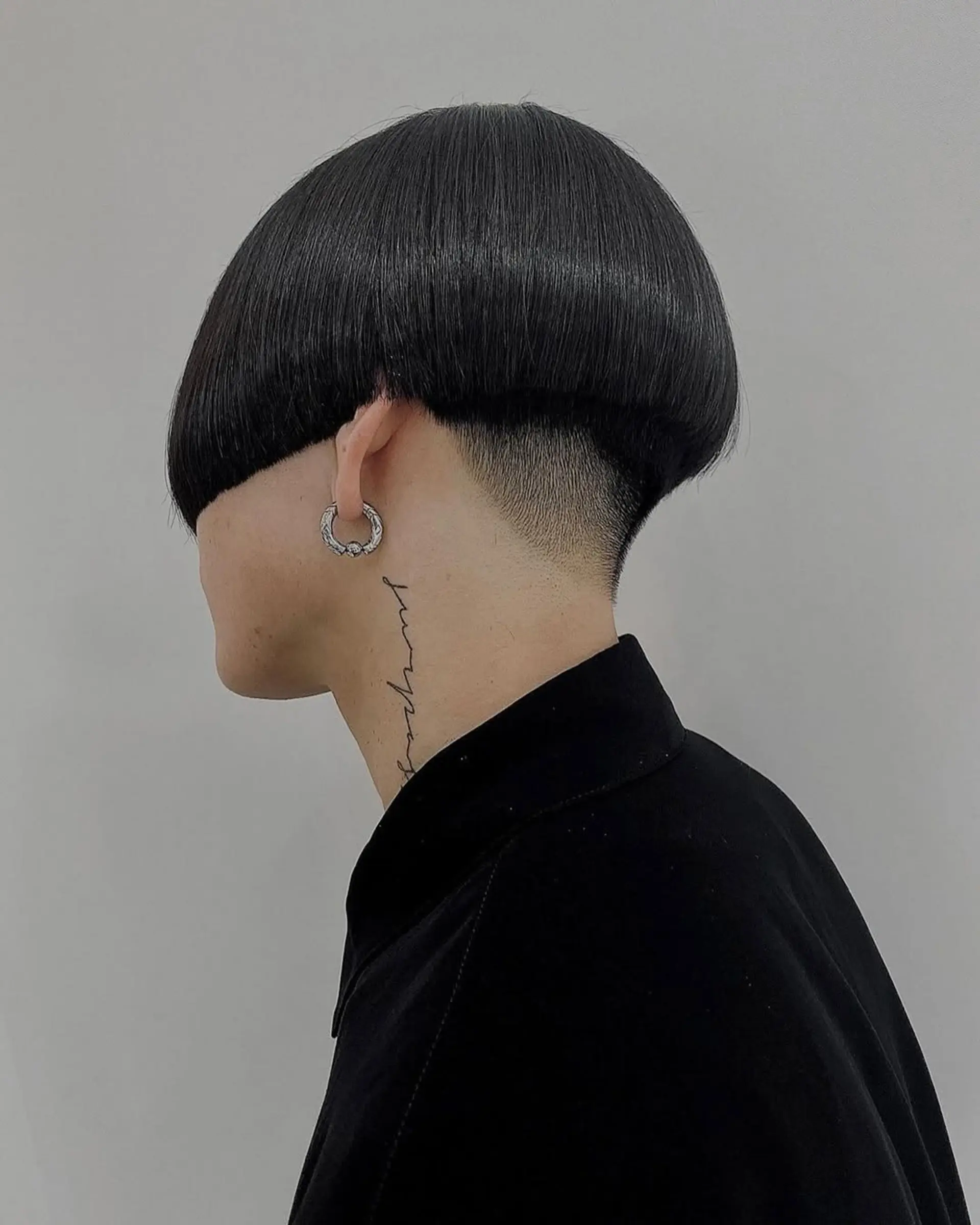Sleek and modern bowl cut with under-buzz, smooth straight black hair, and sharp clean lines. 1