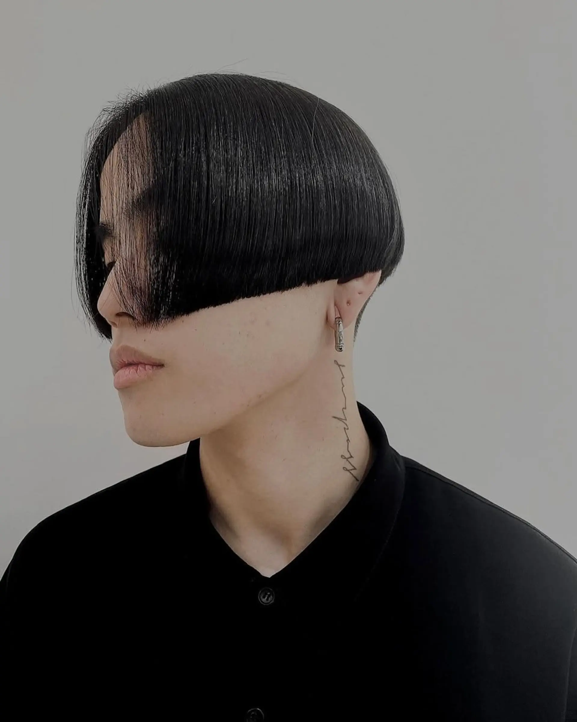 Sleek and modern bowl cut with under-buzz, smooth straight black hair, and sharp clean lines. 2